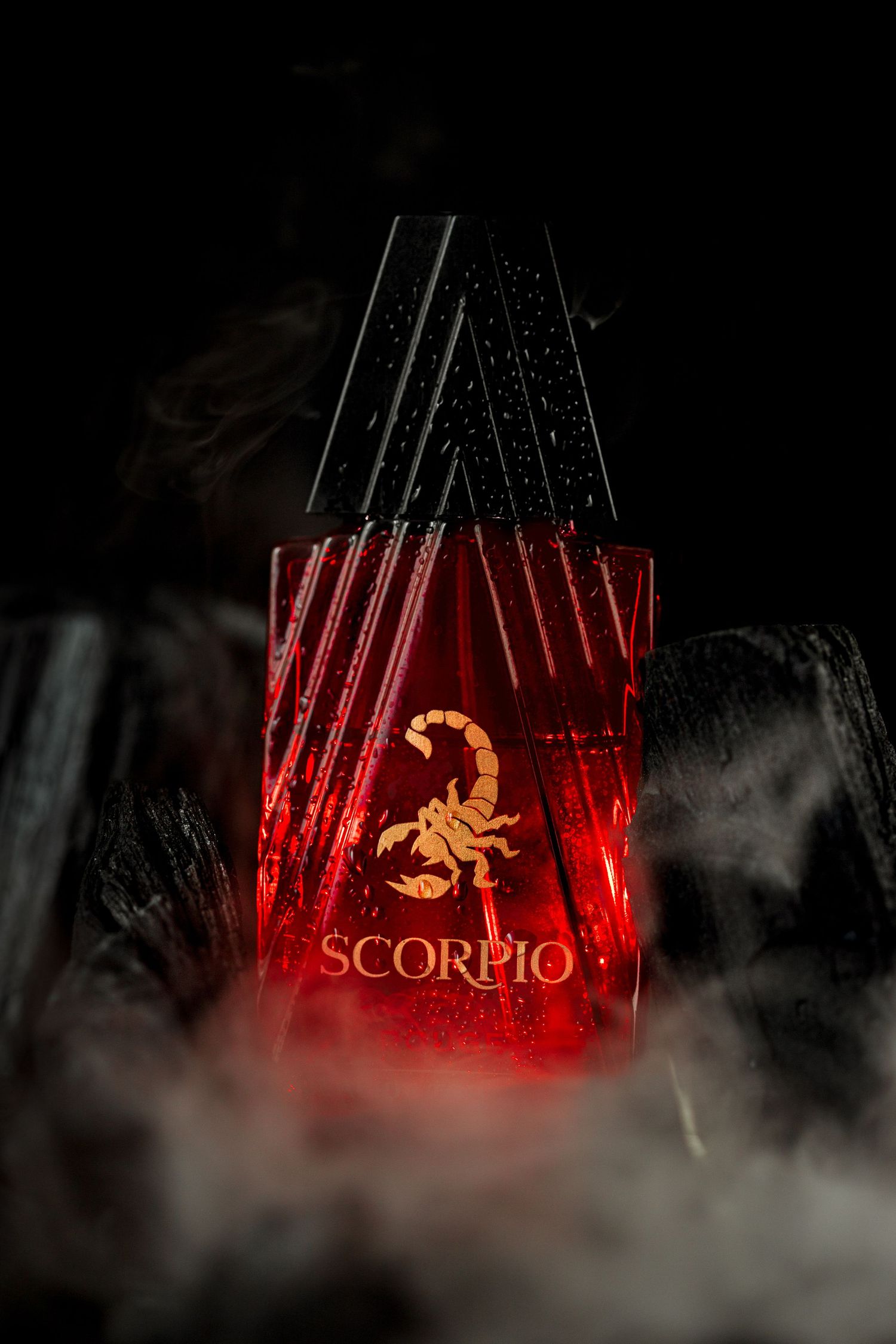 Parfum scorpion bouteille rouge, fond noir avec de la fumé et du charbon