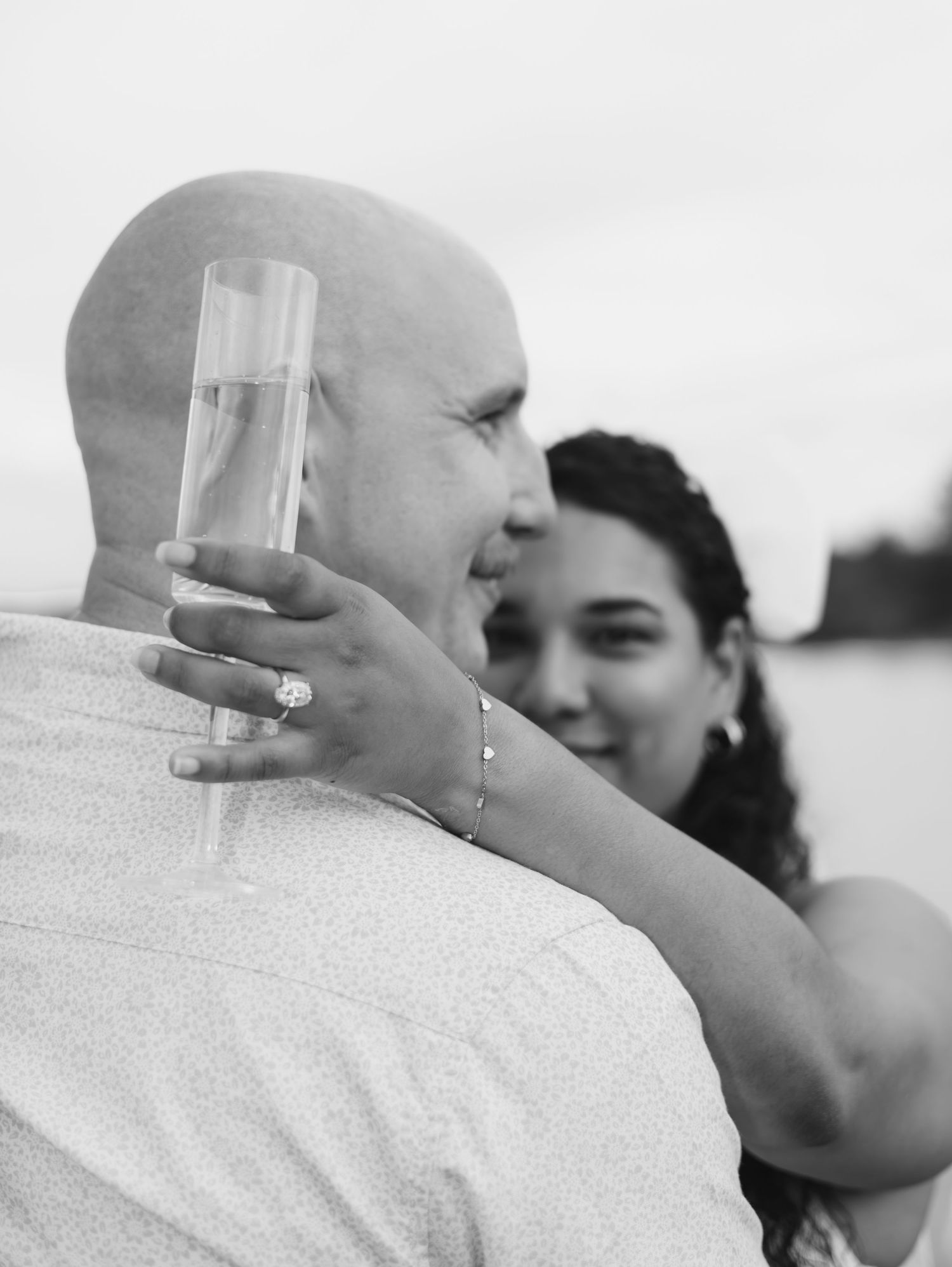 A black and white photo sequence shows a couple toasting with champagne glasses by the water.
