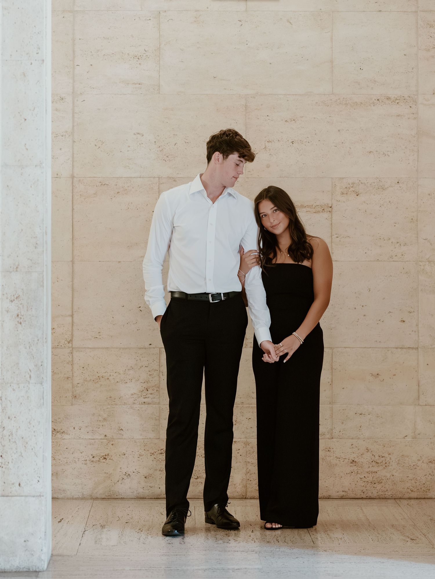A couple in formal attire poses against a beige stone wall in a series of intimate portrait shots.