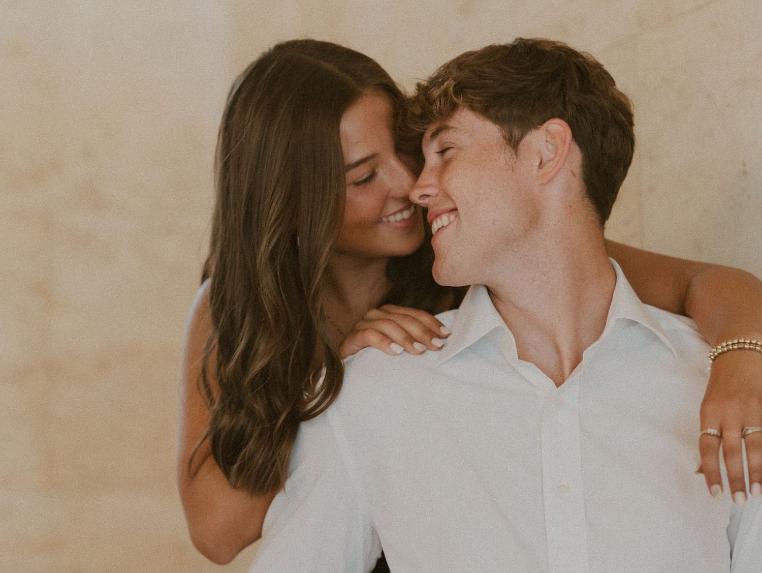 A couple shares an intimate moment while dancing together in a warmly lit room.