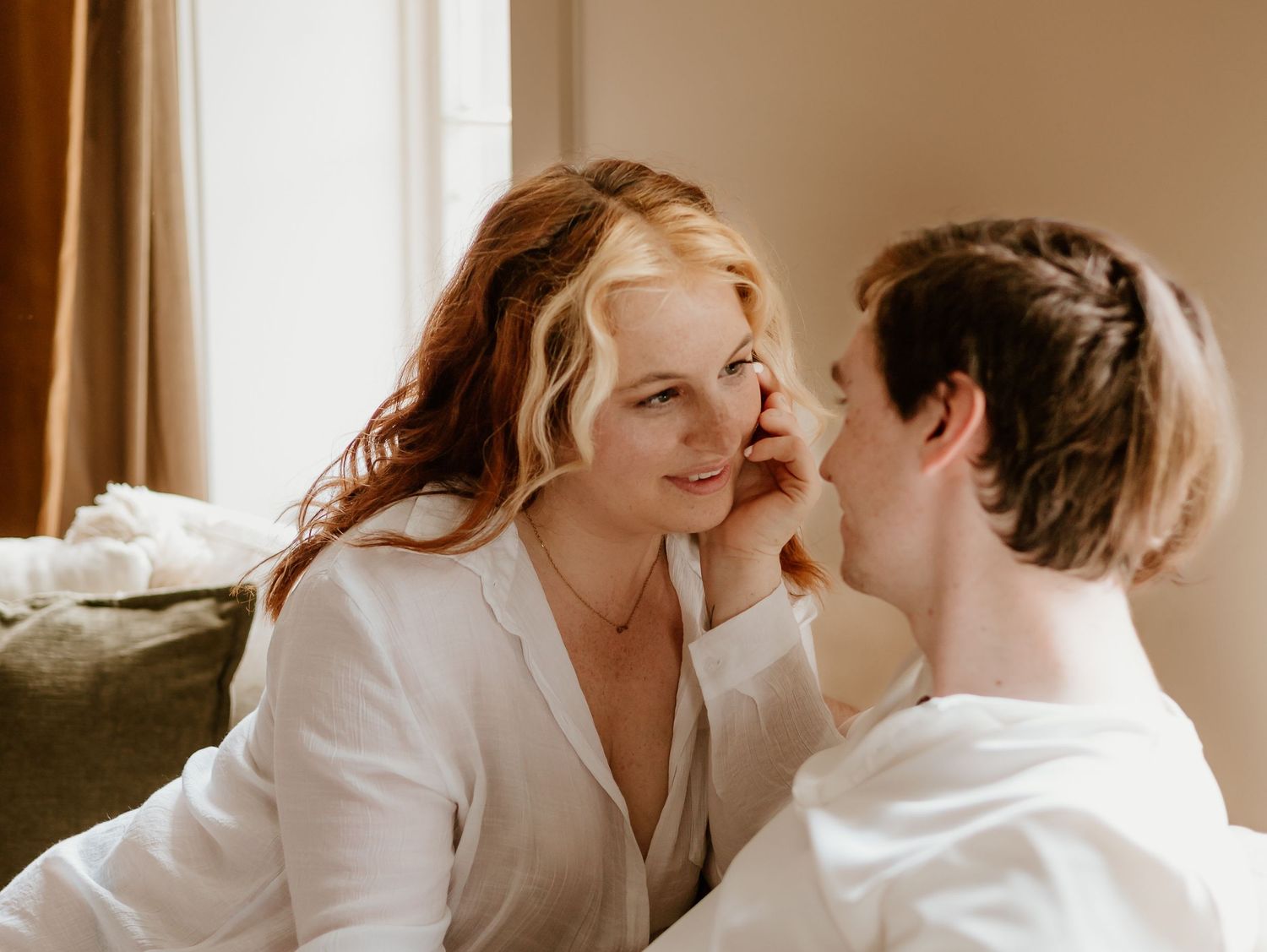 Warm toned intimate portraits of couple in white shirts sharing tender moments.