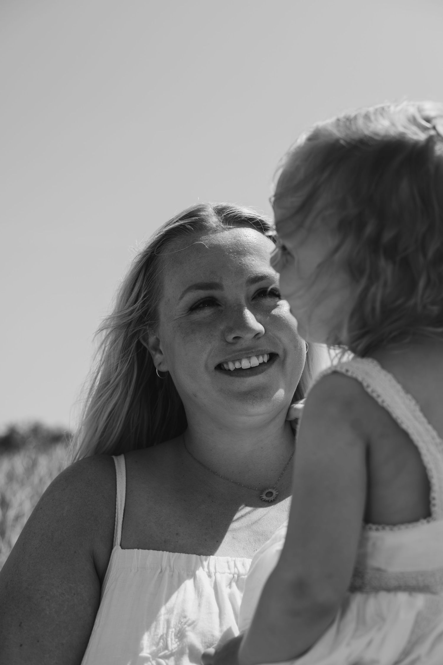 A series of black and white photos showing an intimate couple embracing and smiling together outdoors.