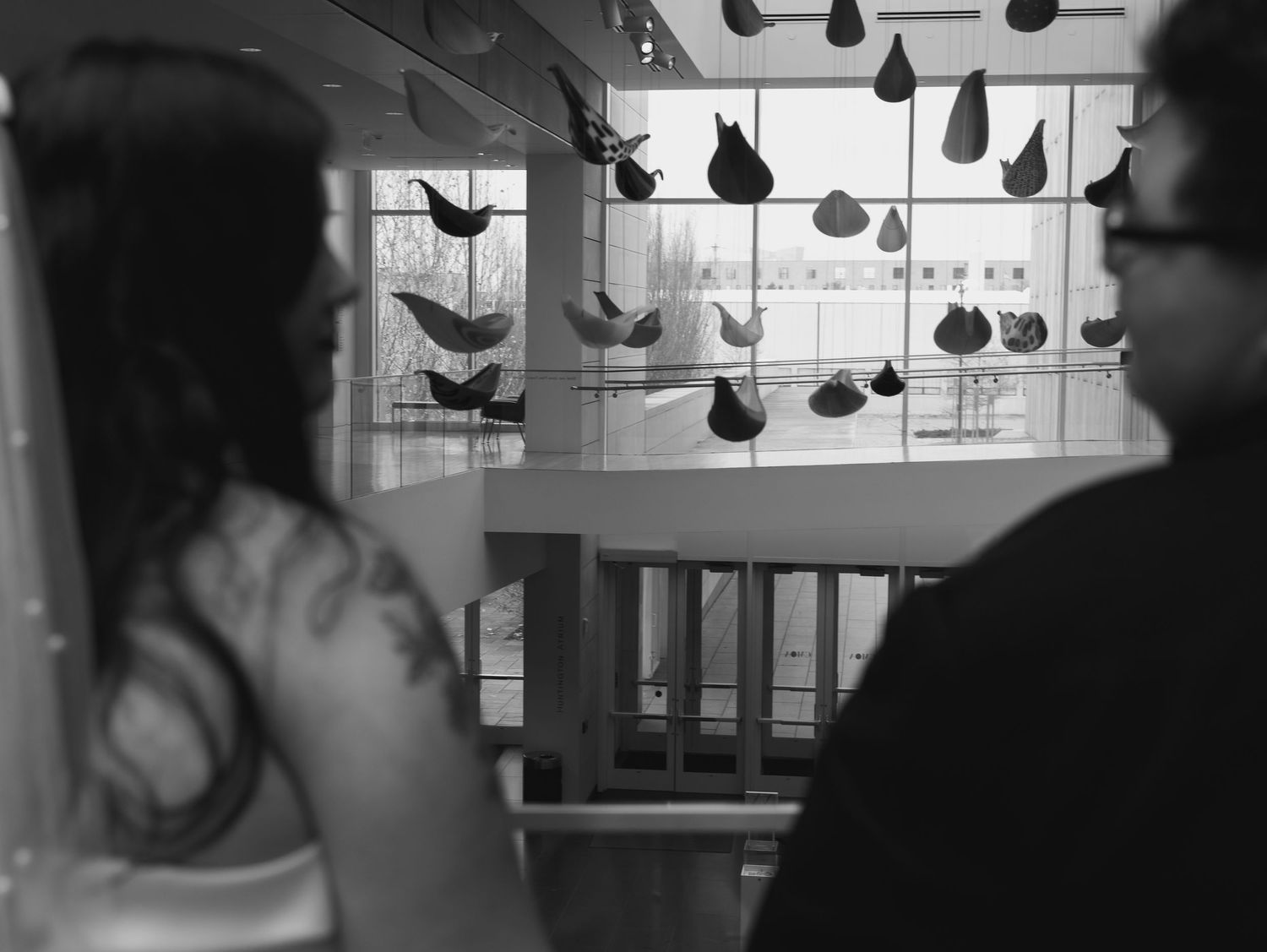 Silhouetted figures at a wedding reception with decorative lights hanging overhead.