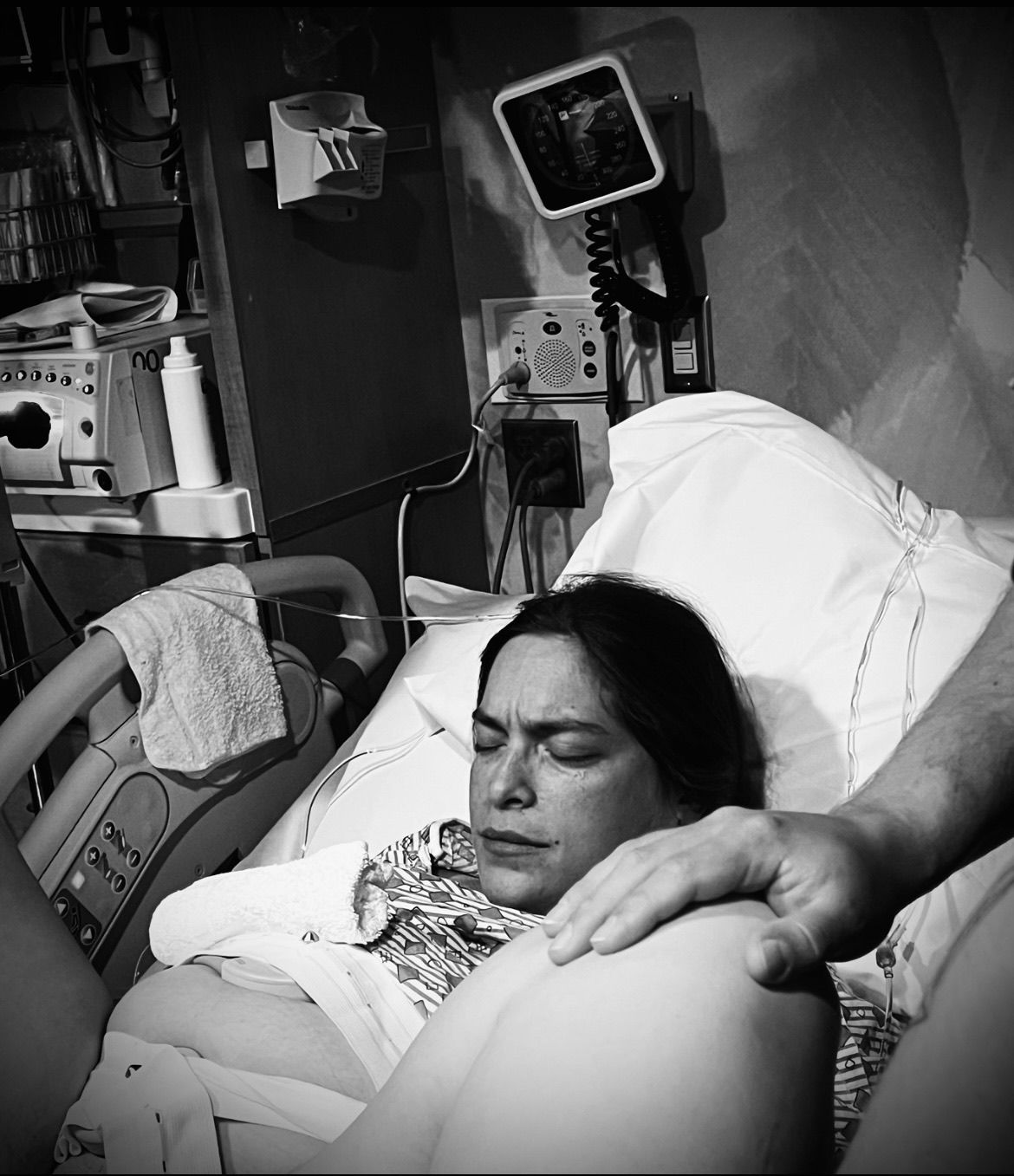 Black and white image of hospital room with medical equipment visible.