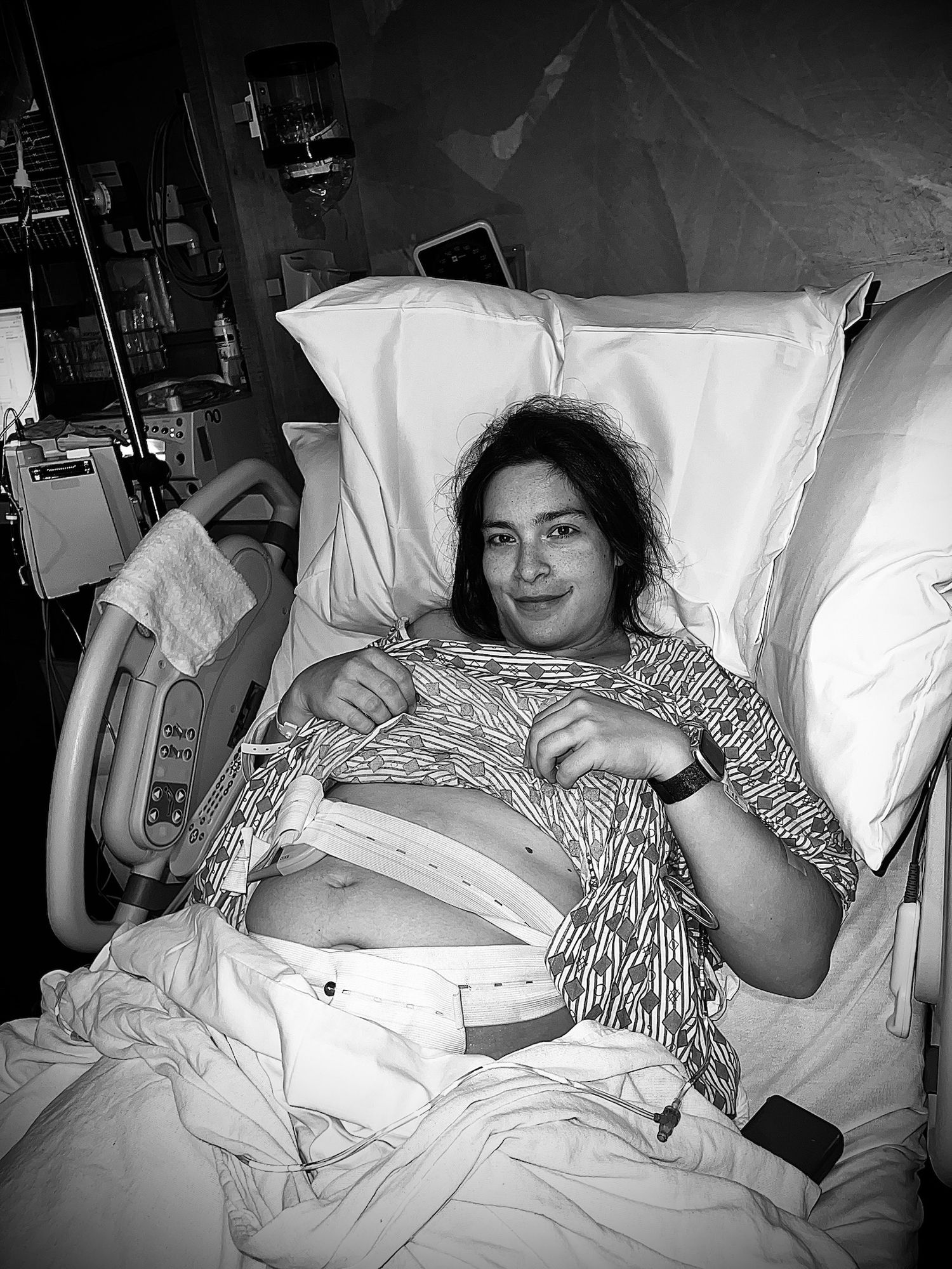 Black and white hospital scene with medical monitors and equipment visible.