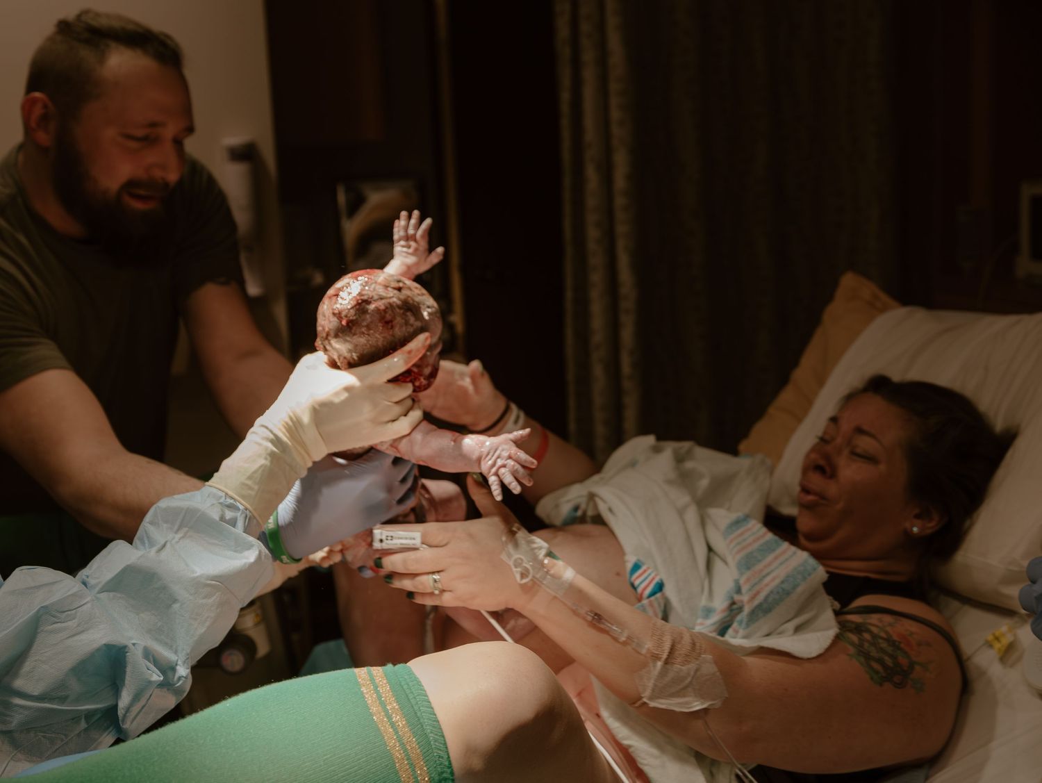 Emotional birth moment captured in hospital room as newborn baby meets parents for first time.