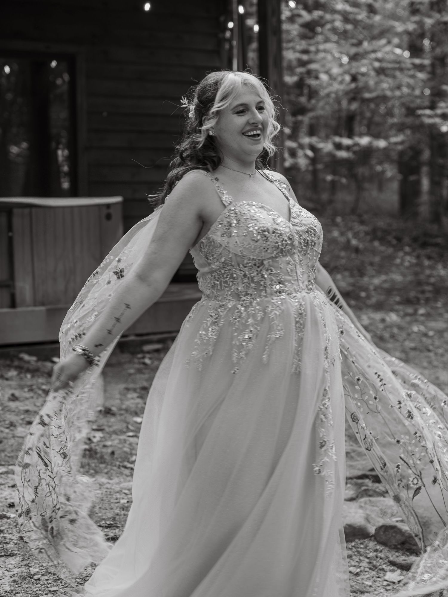 A flowing white wedding dress sparkles with sequins in a black and white outdoor portrait series.