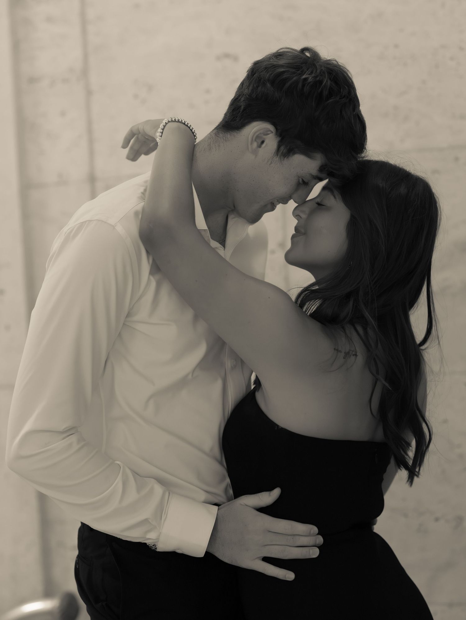 A romantic couple shares an intimate moment in black and white photography.
