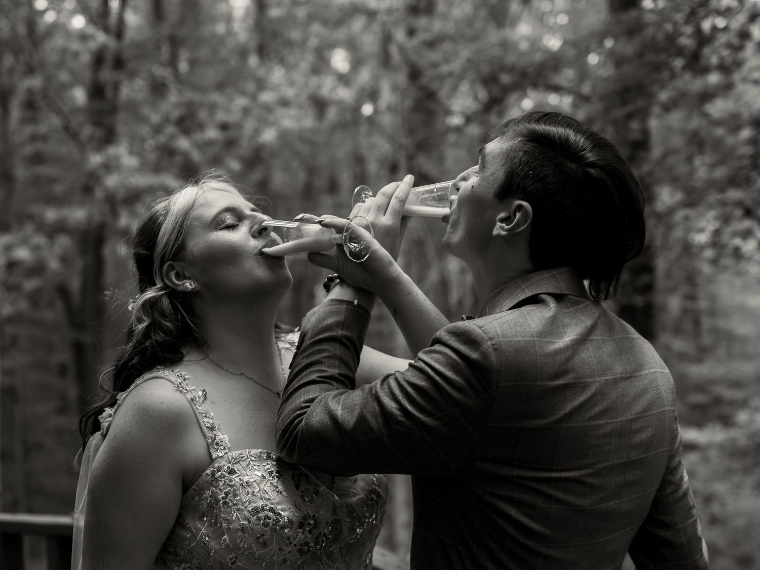 Candid moments captured between wedding party members during an outdoor forest celebration.