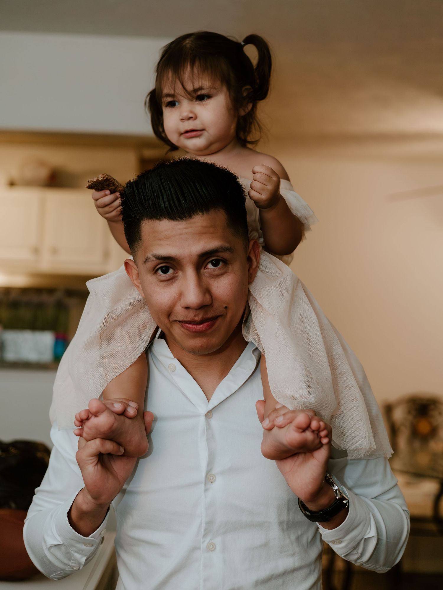 Person in white shirt holds a young child on their shoulders while making playful gestures in sequential photos.