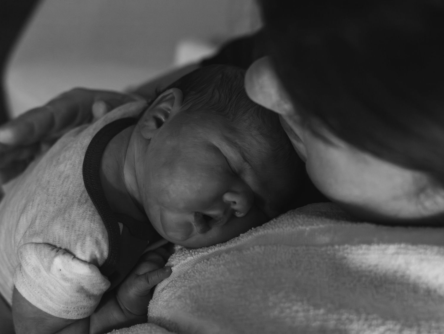 Series of monochrome photographs depicting a baby receiving medical treatment while lying on a hospital bed.
