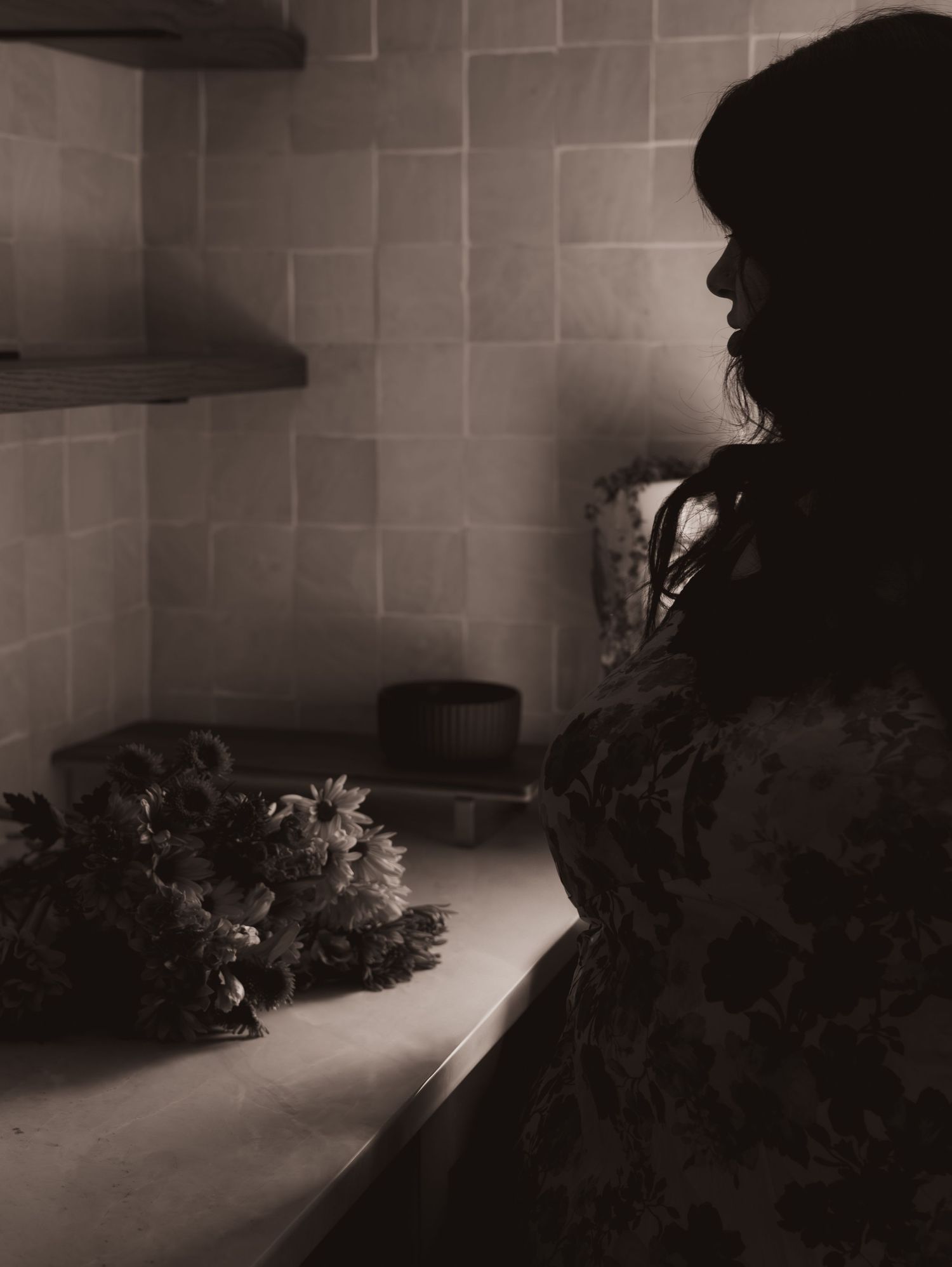 Vintage-style monochrome photograph of a prison cell interior with scattered flowers casting dramatic shadows.