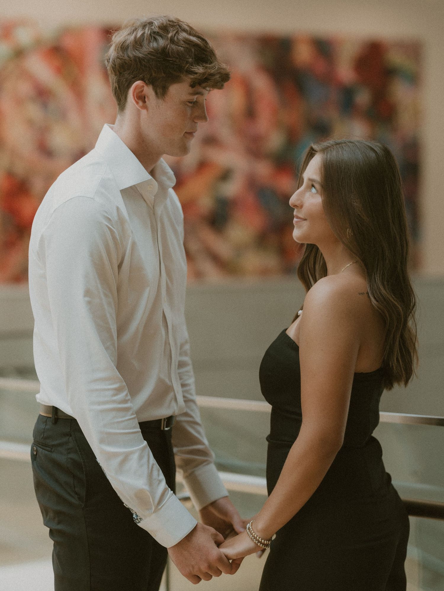 A couple in formal attire sharing tender moments during a dance sequence against a warm-toned background.
