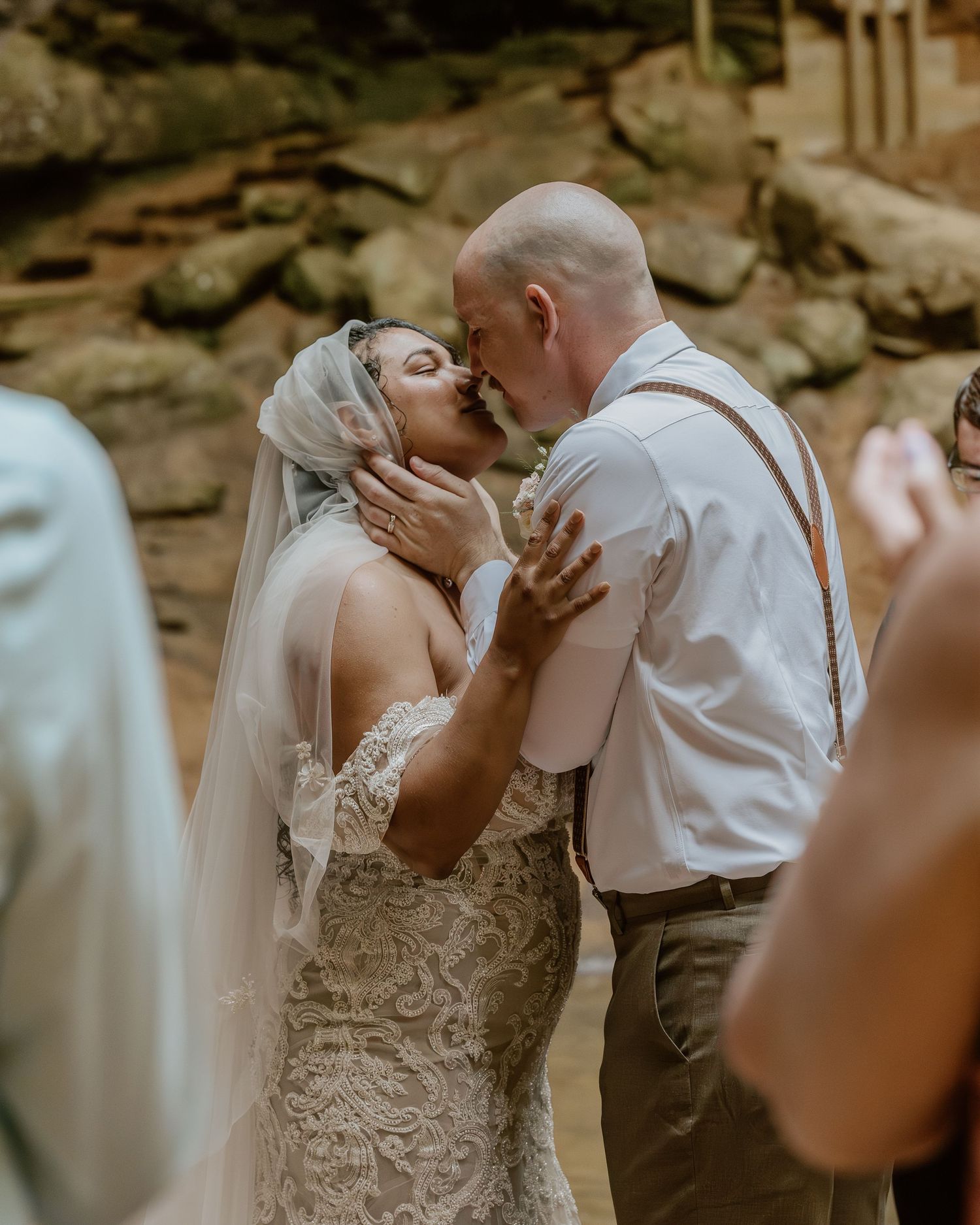 Intimate wedding ceremony moment showing couple exchanging vows in front of stone architecture.