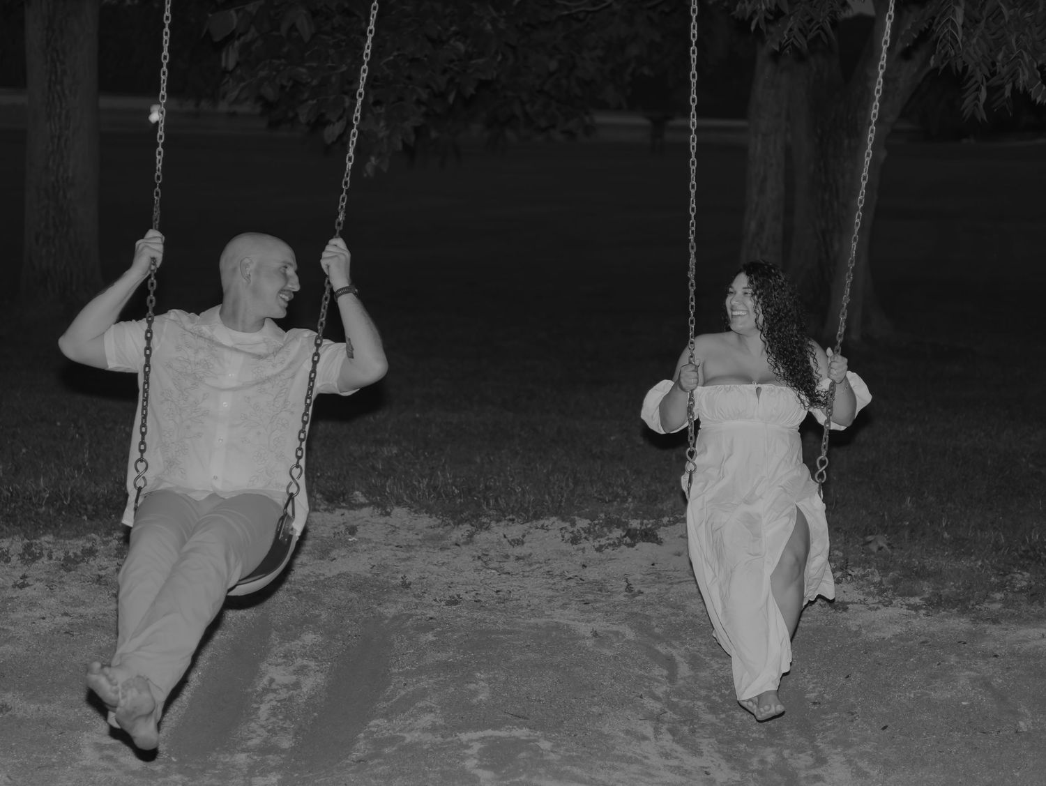 A sequence of black and white photos shows someone swinging back and forth on a playground swing set at night.
