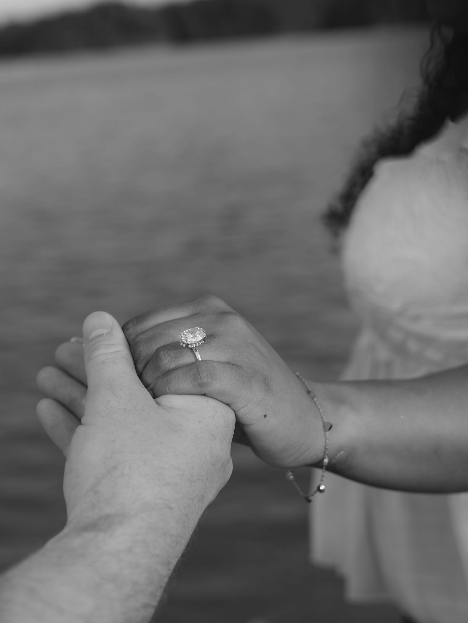 A series of black and white photos showing hands clasped together wearing engagement rings.