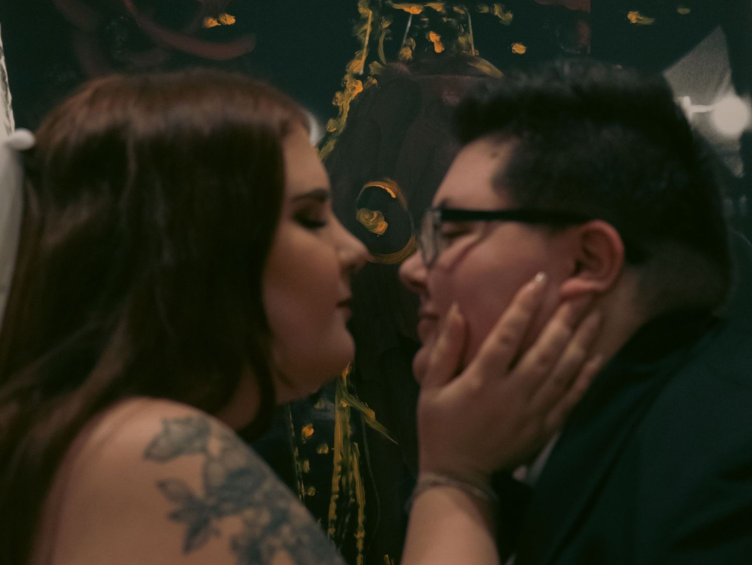 Intimate wedding celebration moment captured in moody lighting with golden accents.