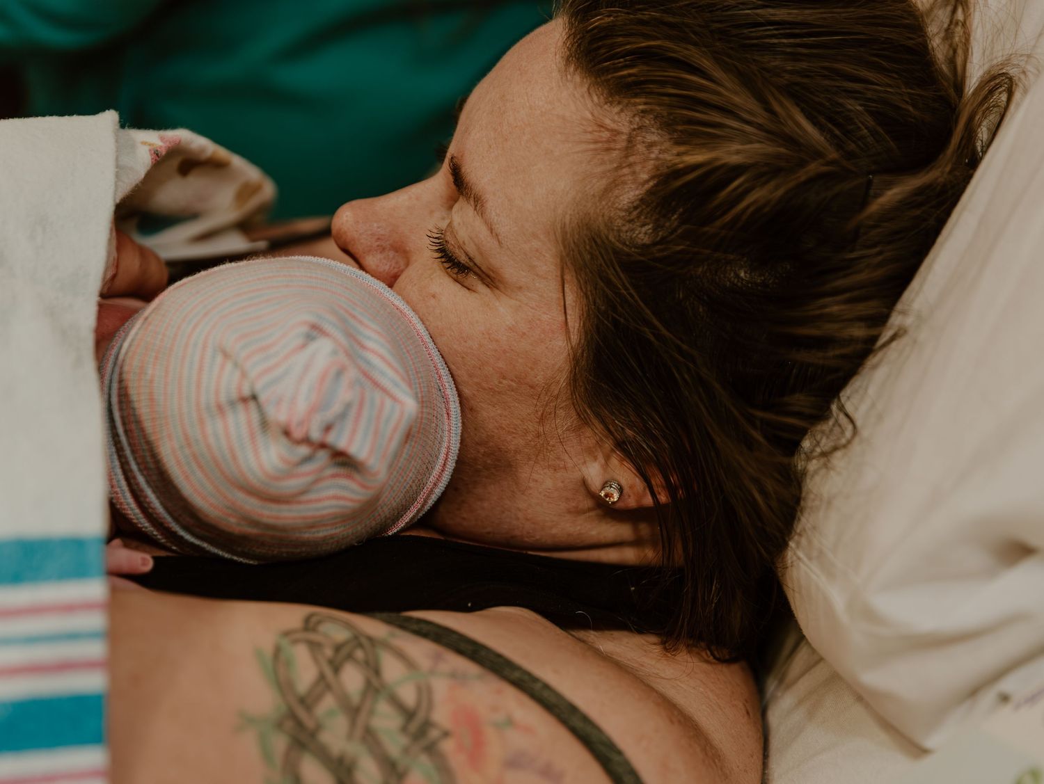 Mother holding a bottle during skin to skin bonding after giving birth in a hospital setting.