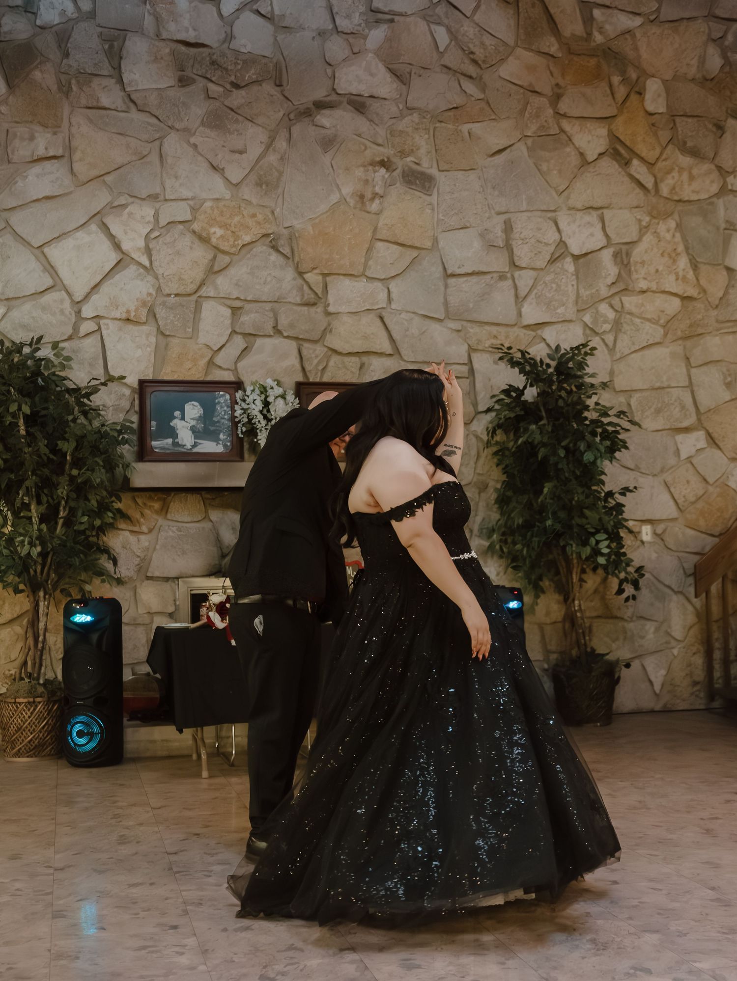 Couple sharing a romantic dip dance in a black sequin ballgown at a gothic wedding reception.