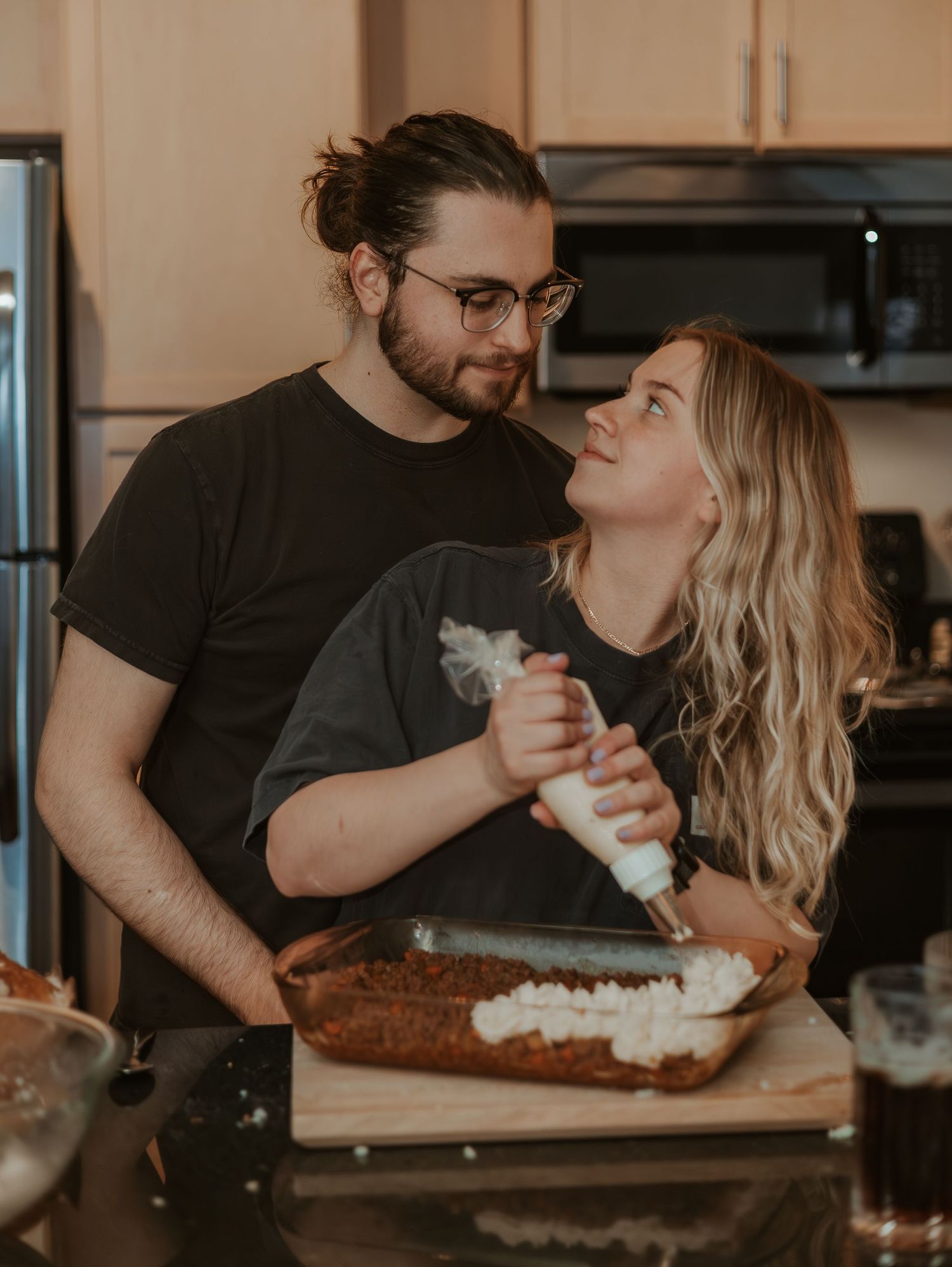Couple sharing a romantic moment while enjoying a meal together at home in a cozy kitchen setting.