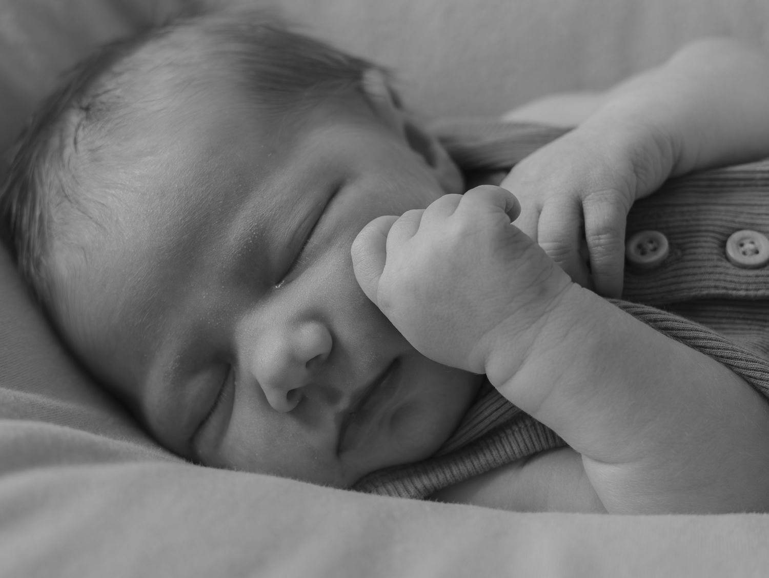 Black and white portrait of peaceful sleeping infant in soft natural light.