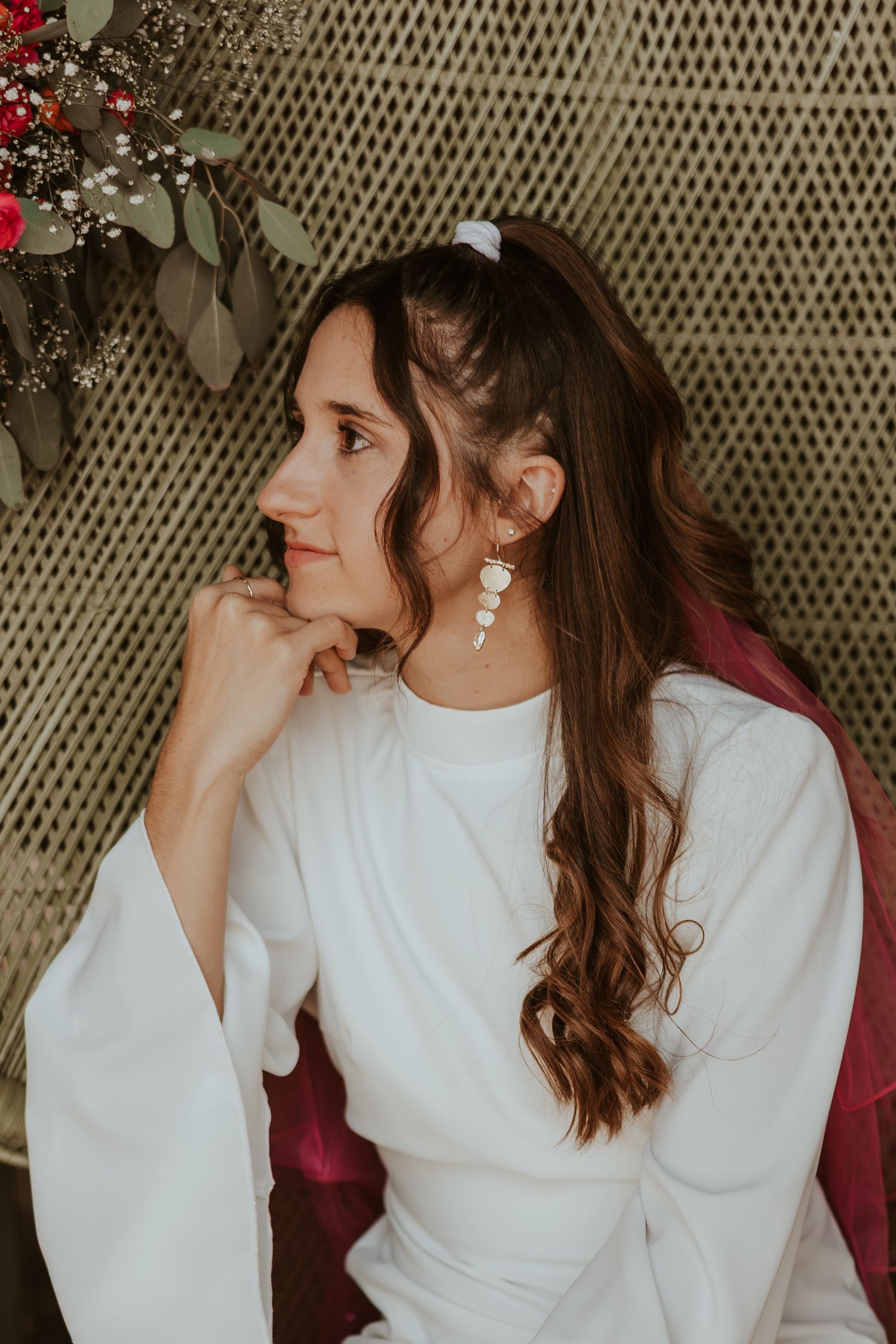 Person with long brown hair in a white sweater poses against textured wall background creating dynamic side profile shots.