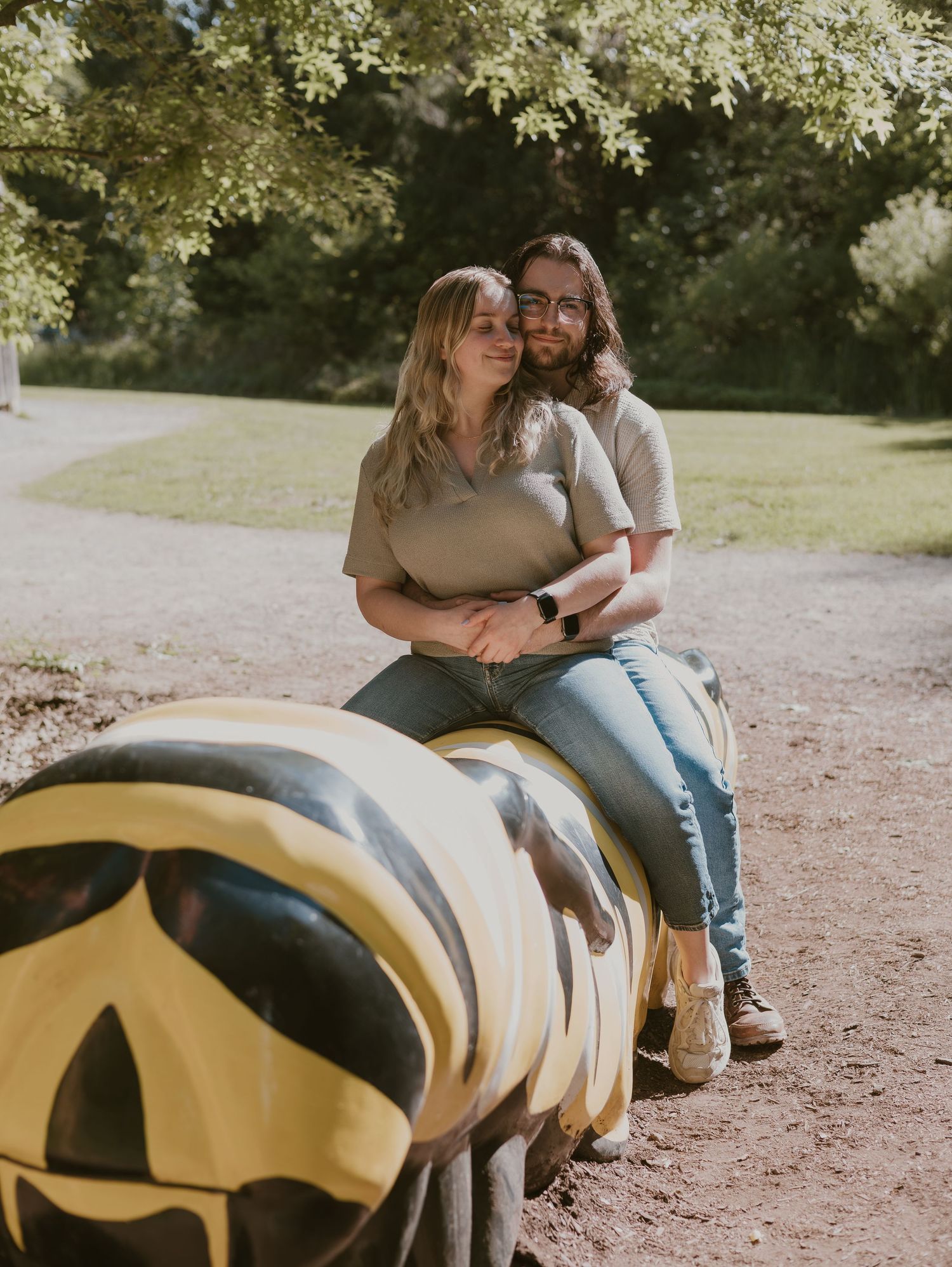 A romantic sequence of a couple sitting together on a yellow playground structure in a park setting.
