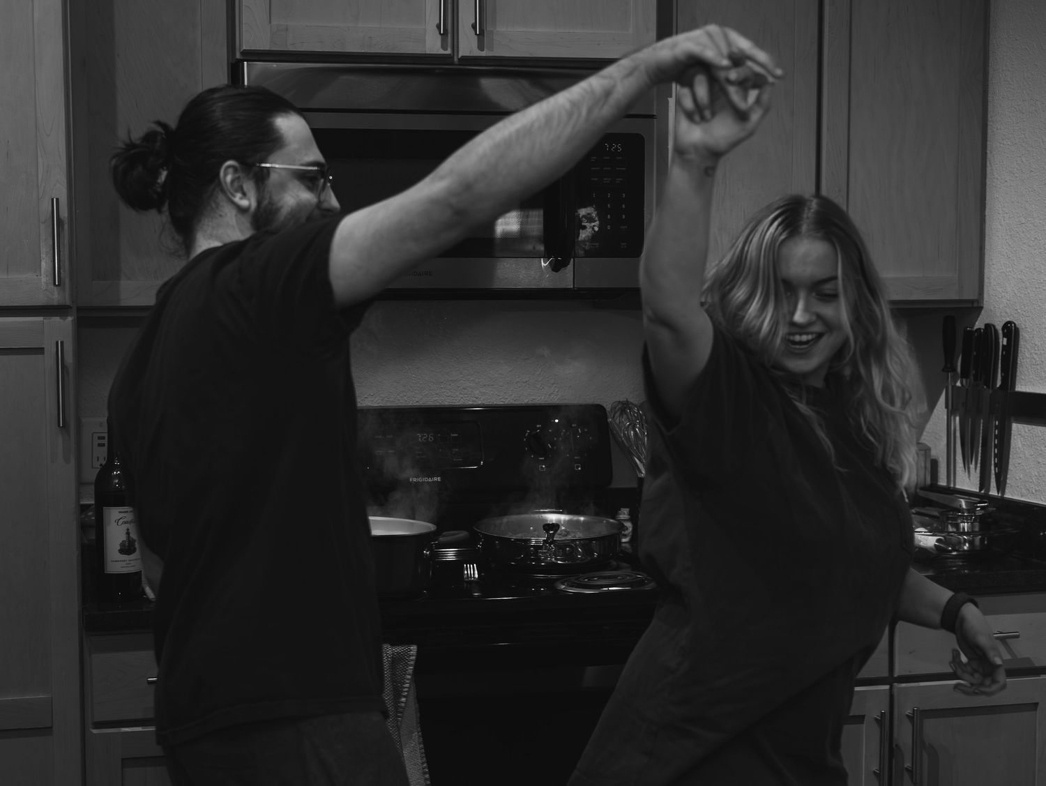 A series of black and white photos showing someone demonstrating steps for cooking in a kitchen.
