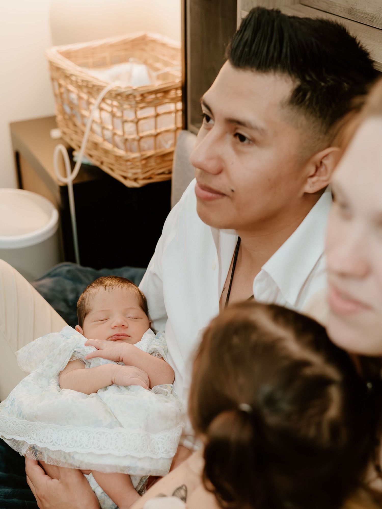 Newborn baby wrapped in white lace blanket being held in a series of gentle poses.