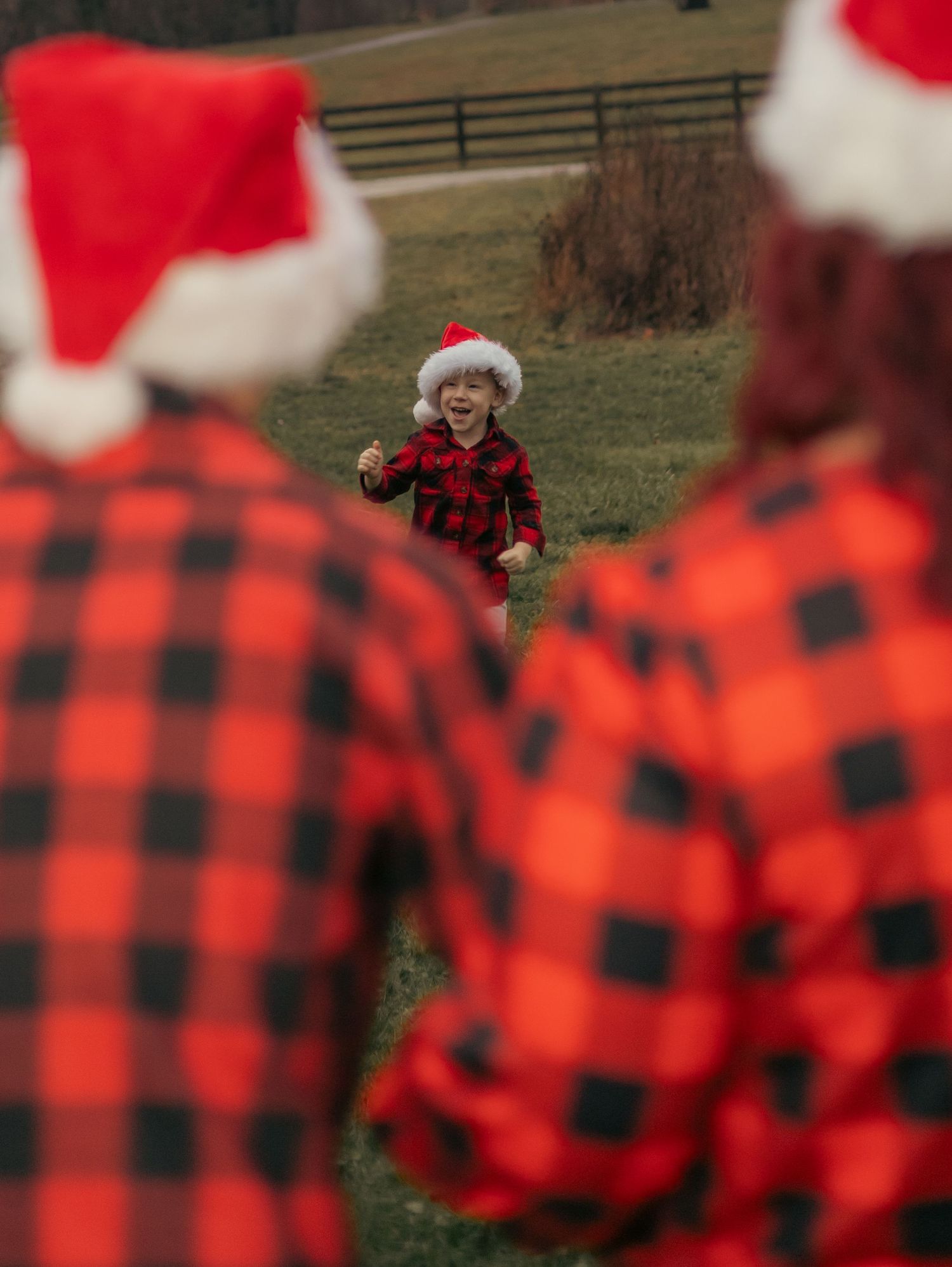 A festive outdoor scene with buffalo plaid shirts and Santa hats framing a central figure.