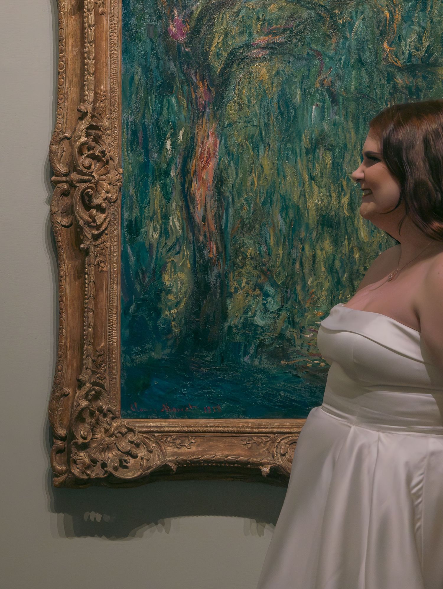 Wedding dress and elegant gold frame painting create romantic composition in artistic setting.