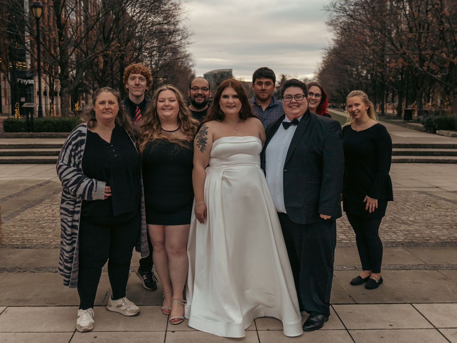 Group gathered outdoors on a winter day wearing formal and casual attire.