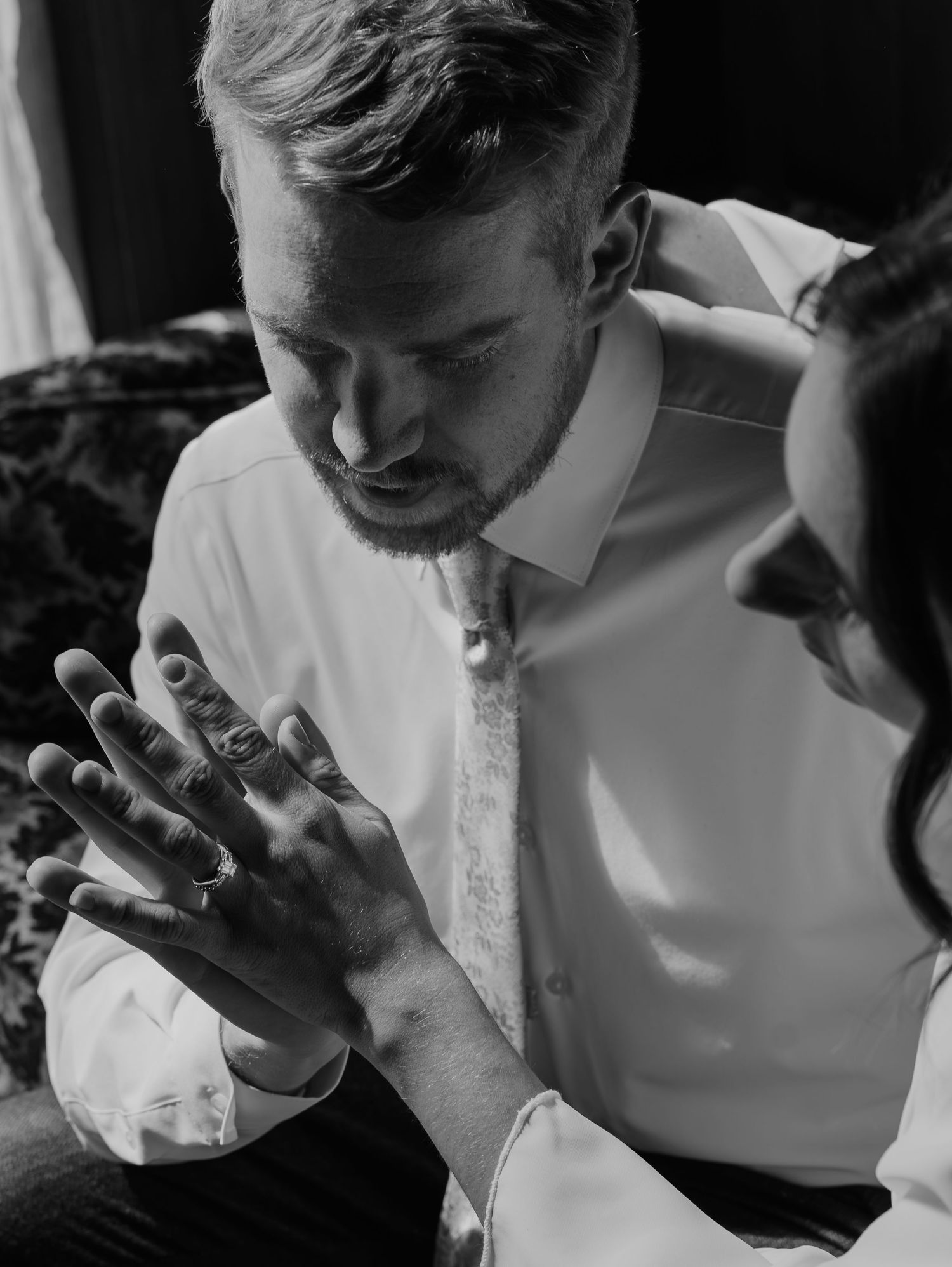 Person wearing a white shirt gestures with hands in a sequence of black and white photos.