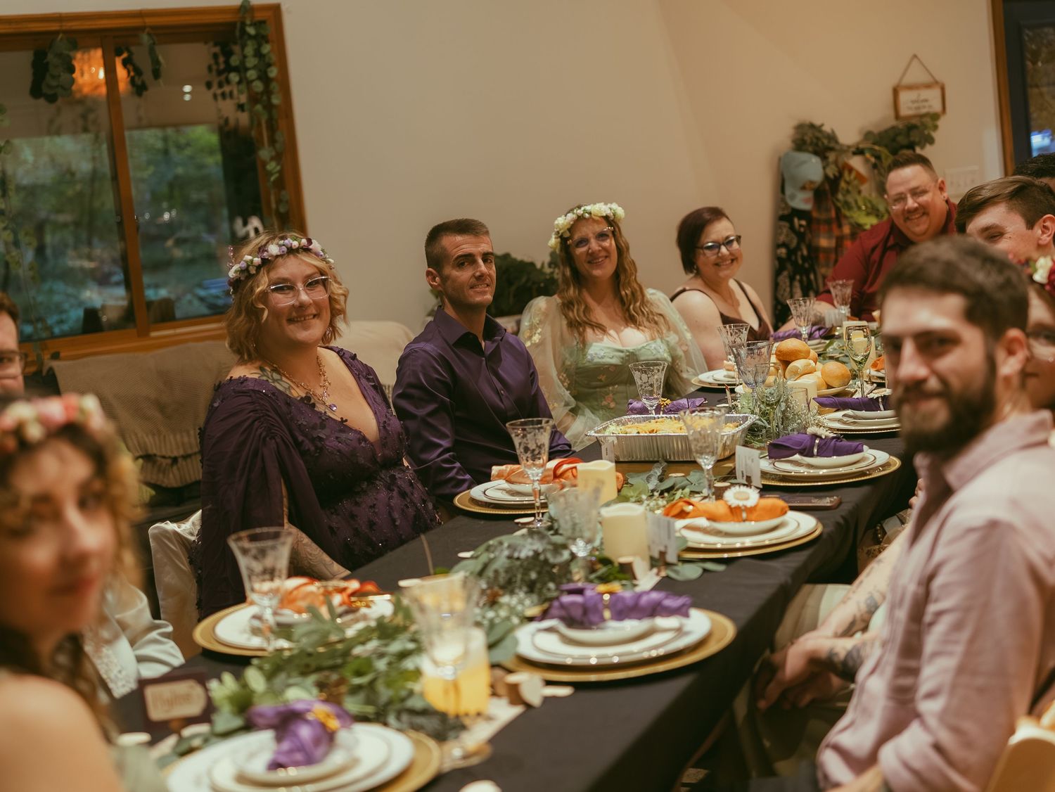 Wedding reception dinner table with guests seated around enjoying a meal and conversation.