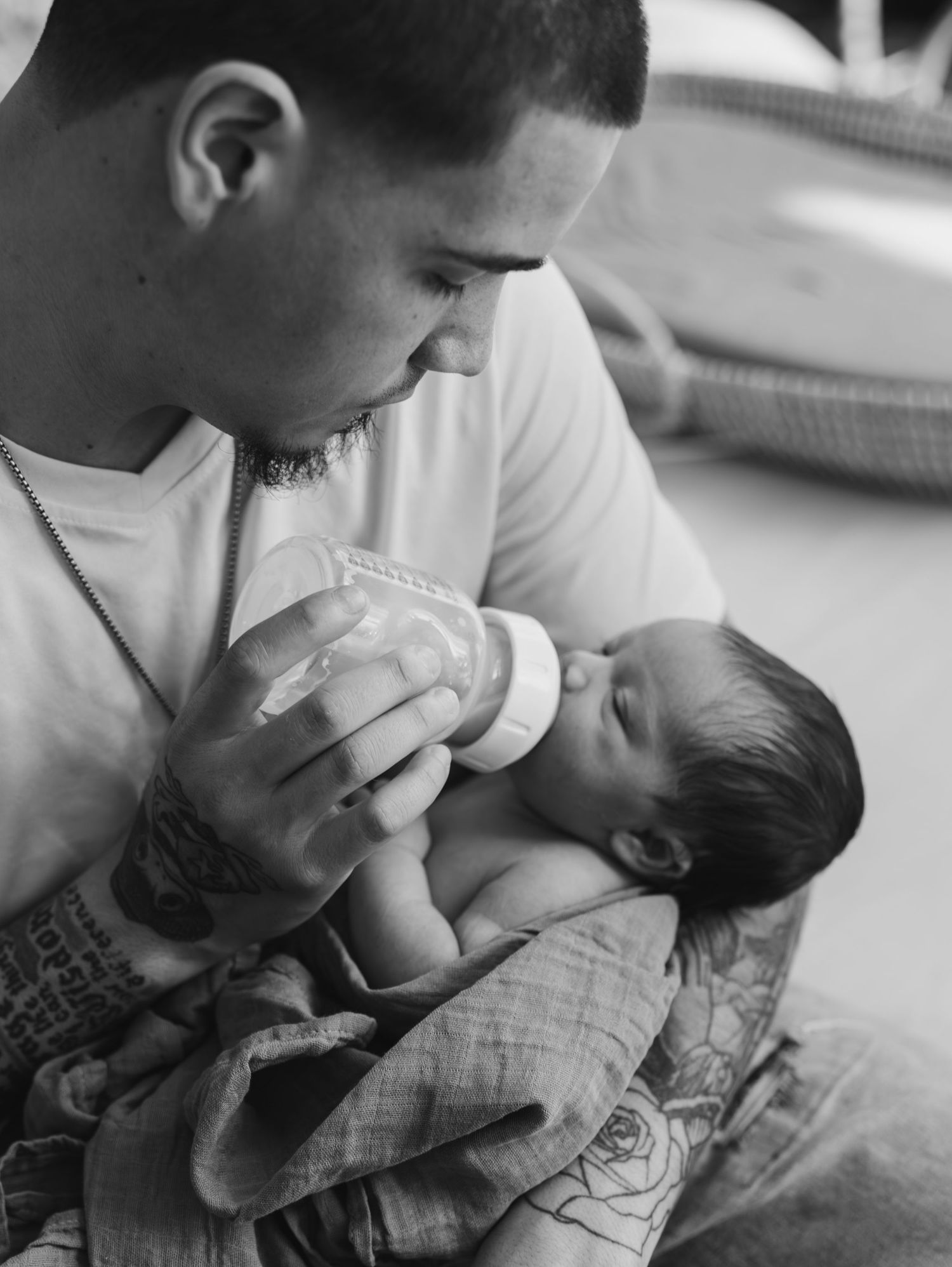 A tender moment between parent and baby as they share an intimate embrace in black and white.