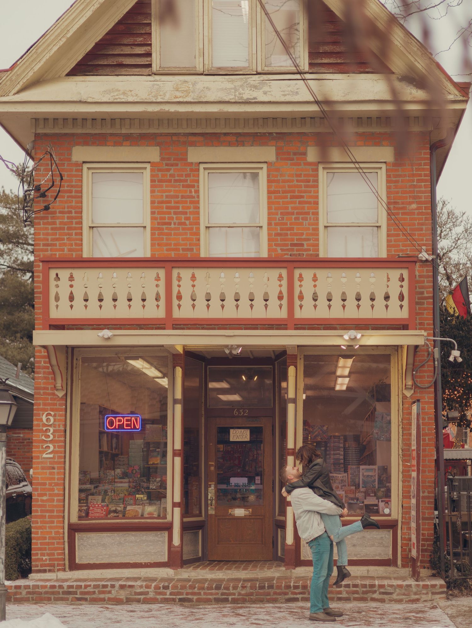 A vintage brick storefront with large display windows and classic architectural details in a small town setting.
