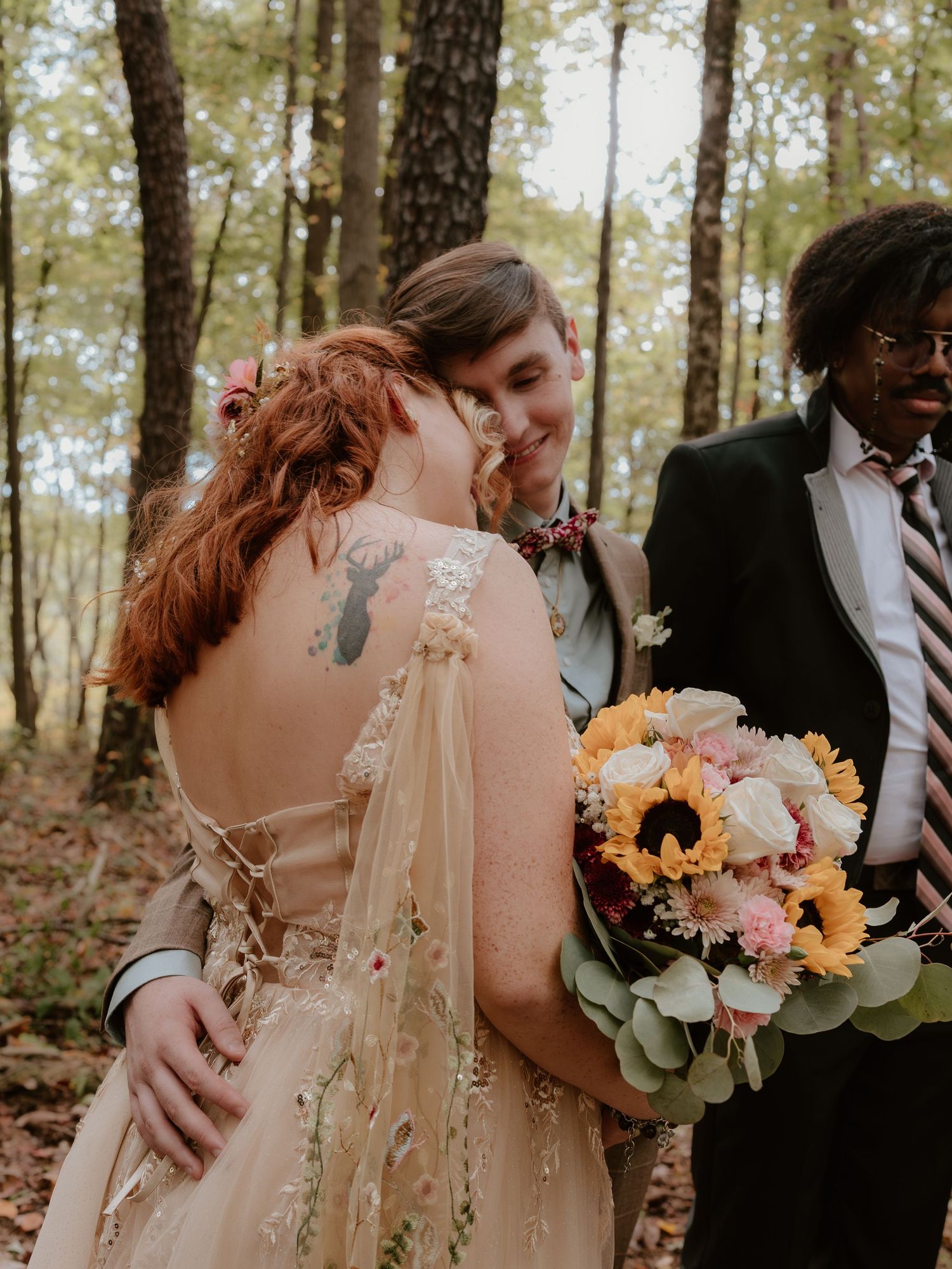 Wedding ceremony in forest with couple and officiant surrounded by trees.
