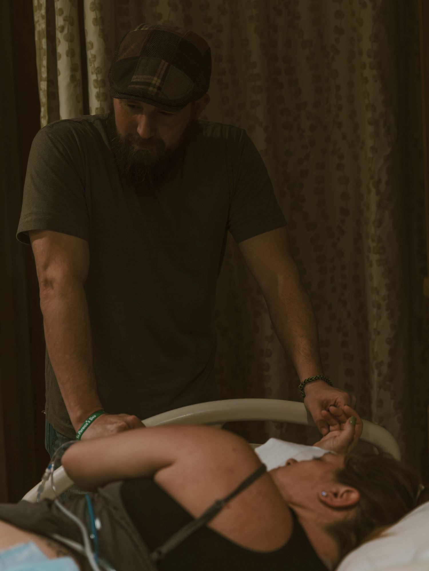 A medical professional performs manual therapy on a patient lying on a treatment table in a dimly lit room.