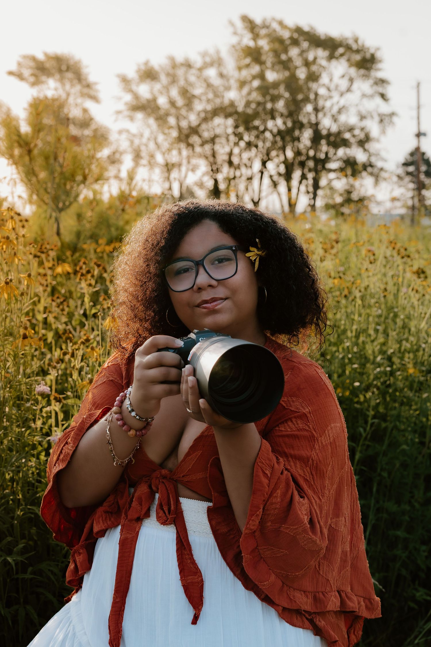A series of photos capturing a photographer in a rust-colored jacket taking pictures in front of autumn foliage.