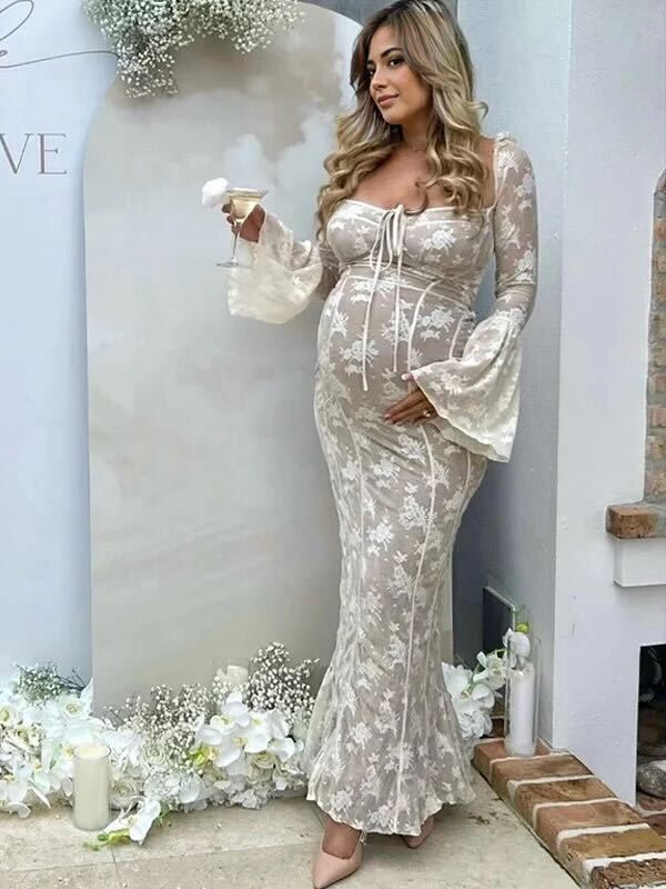 Elegant lace maternity dress with white floral pattern, bell sleeves and mermaid silhouette styled with nude heels.