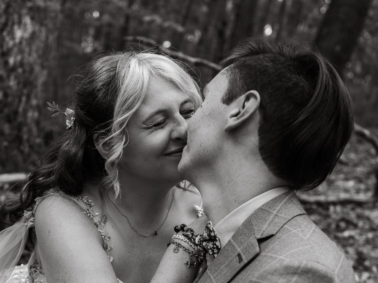 Romantic black and white photo sequence of a couple sharing tender moments in the woods.