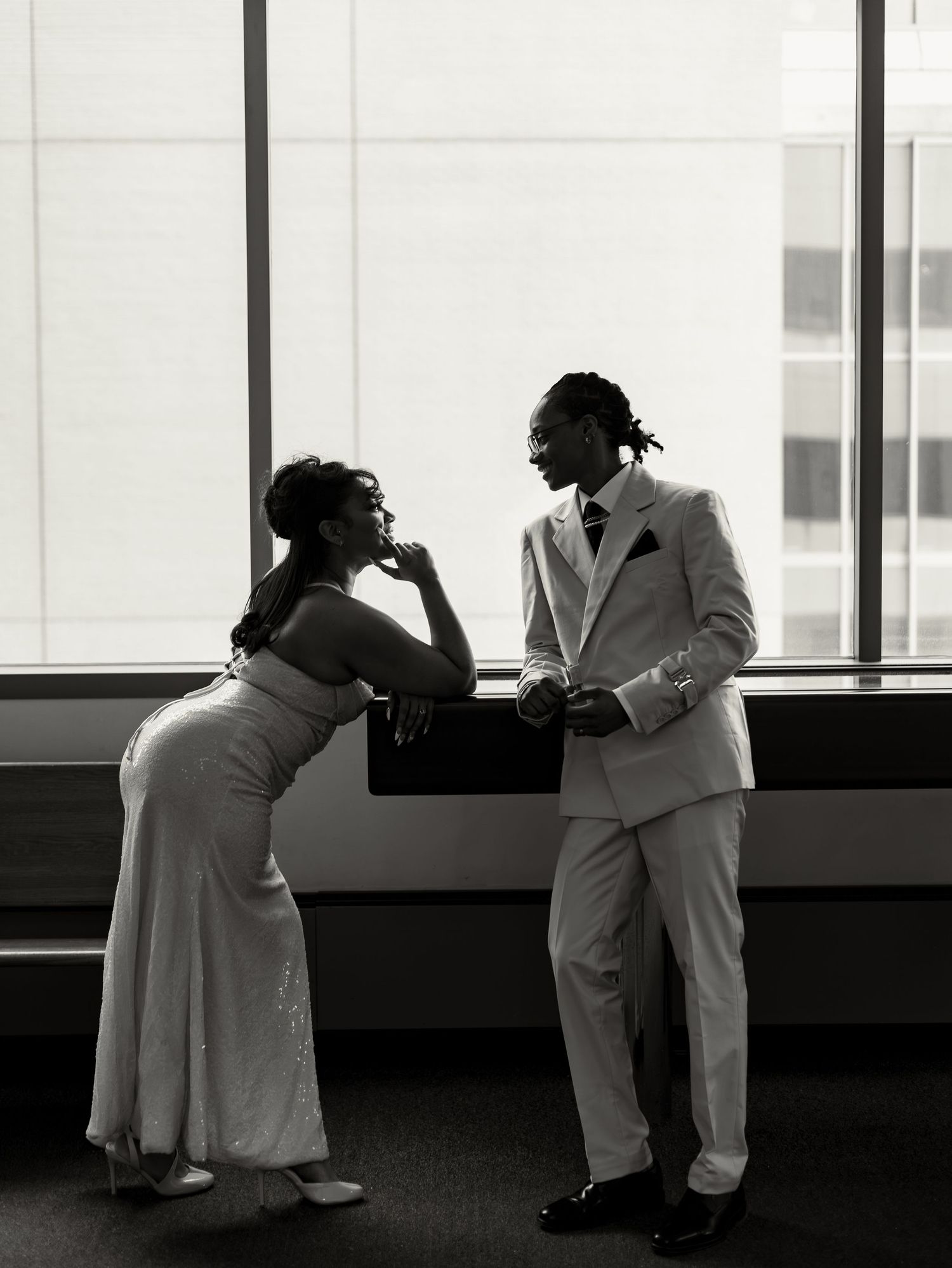 A black and white photo series shows a couple in white clothing dancing together near a window.