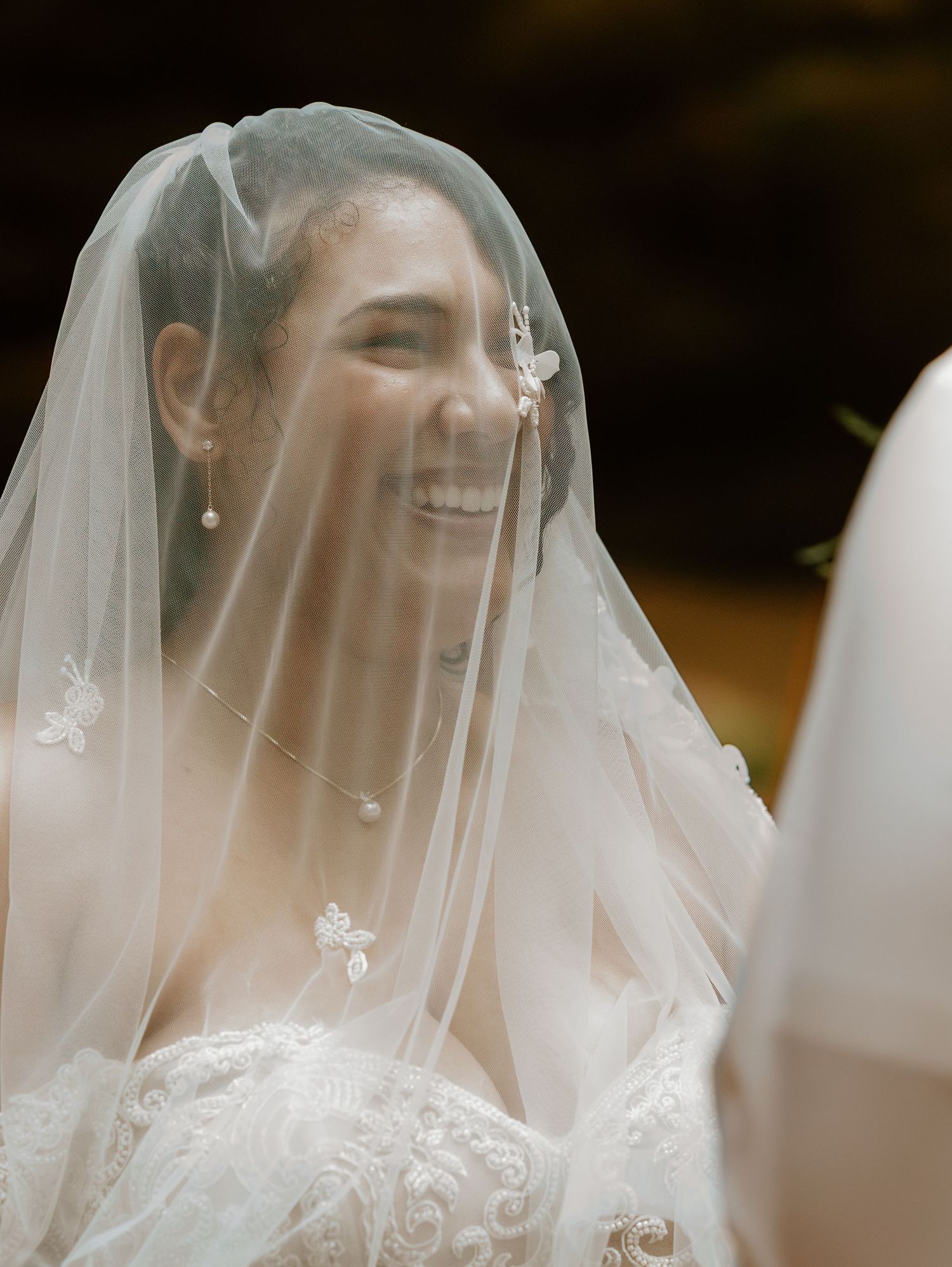 Close-up view of a delicate bridal veil with intricate lace details and embroidered butterflies.