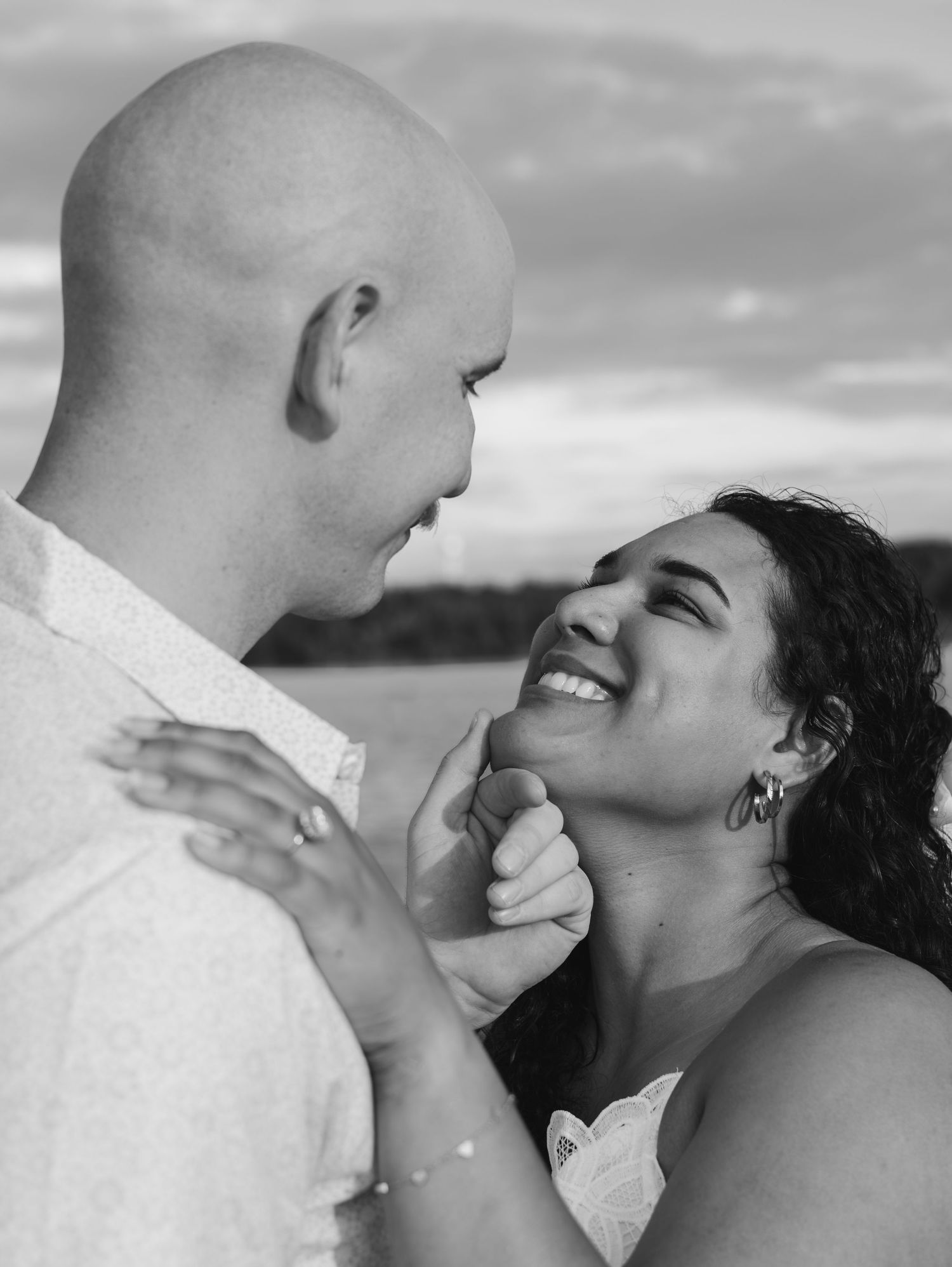 Black and white romantic portrait series showing tender intimate moments between a couple by the water.