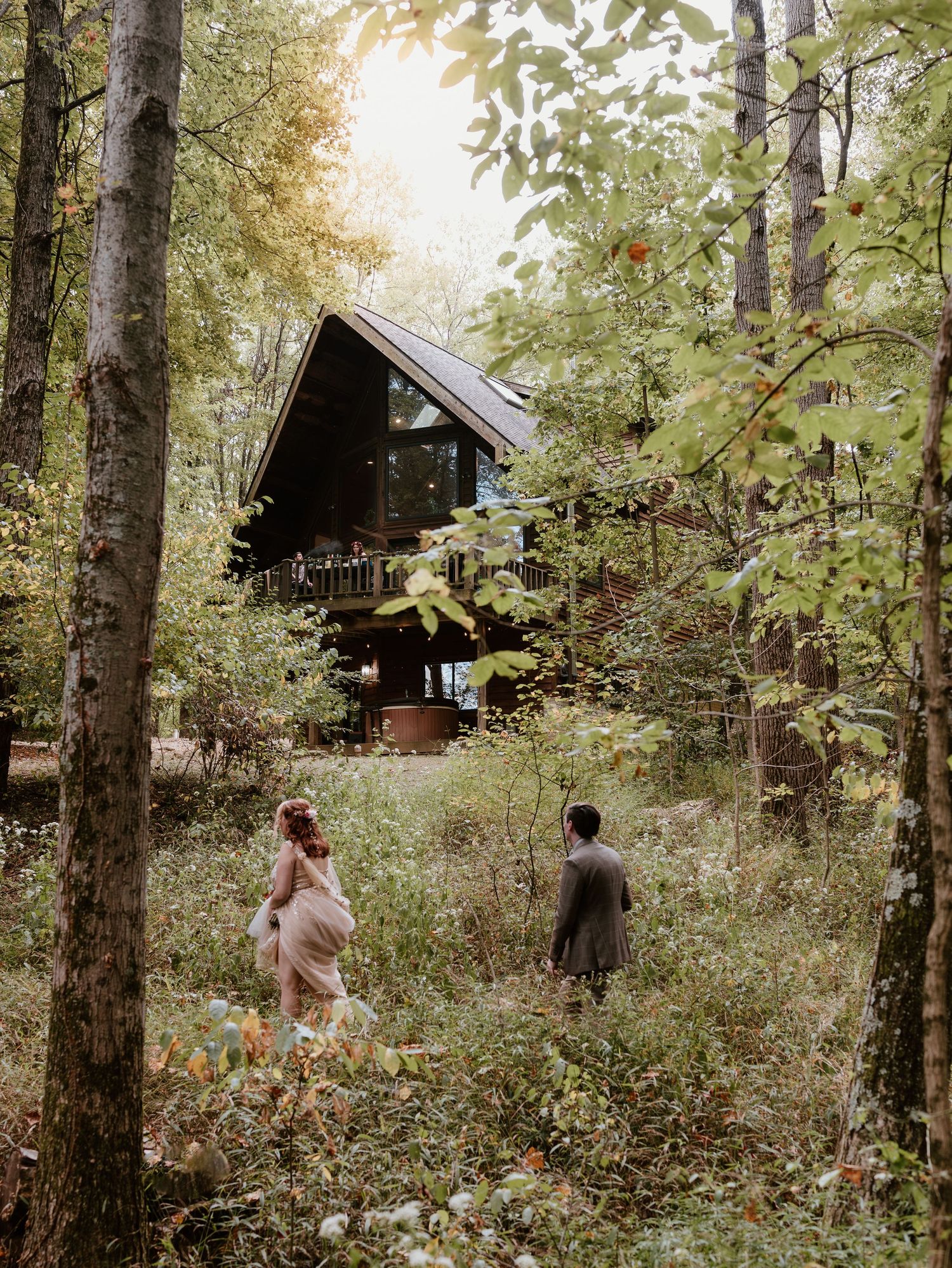 Small wooden cabins nestled among trees in a forest setting during golden hour create a peaceful wilderness retreat atmosphere.