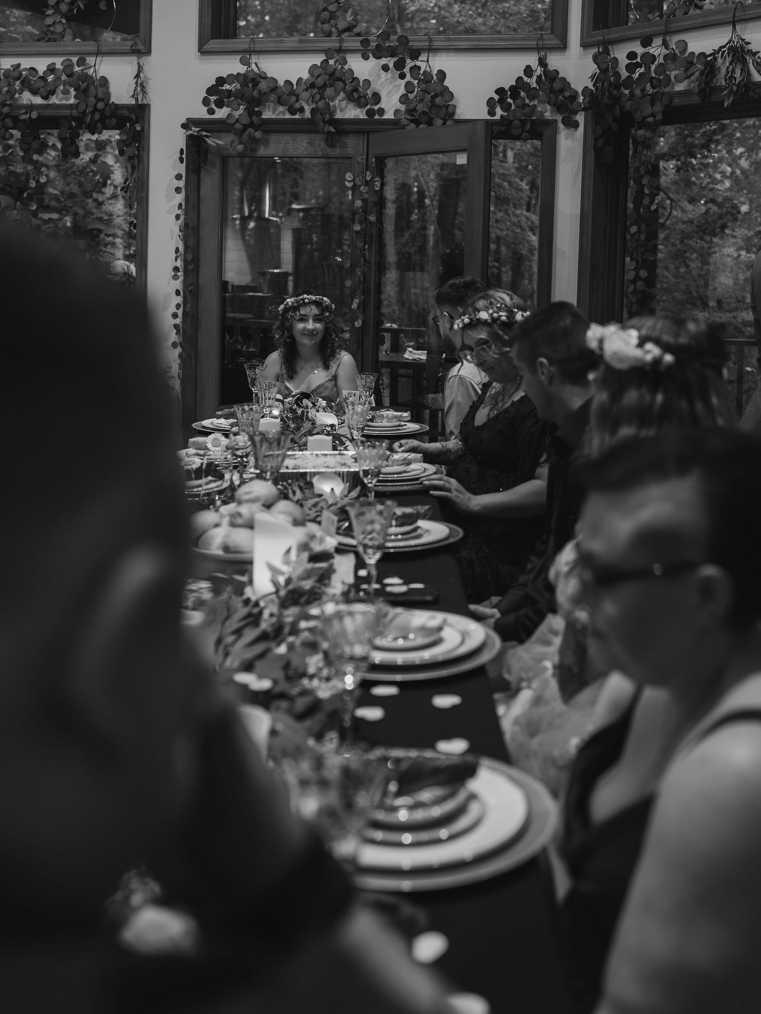 Wedding reception dinner table set with elegant place settings and decorative elements in black and white.