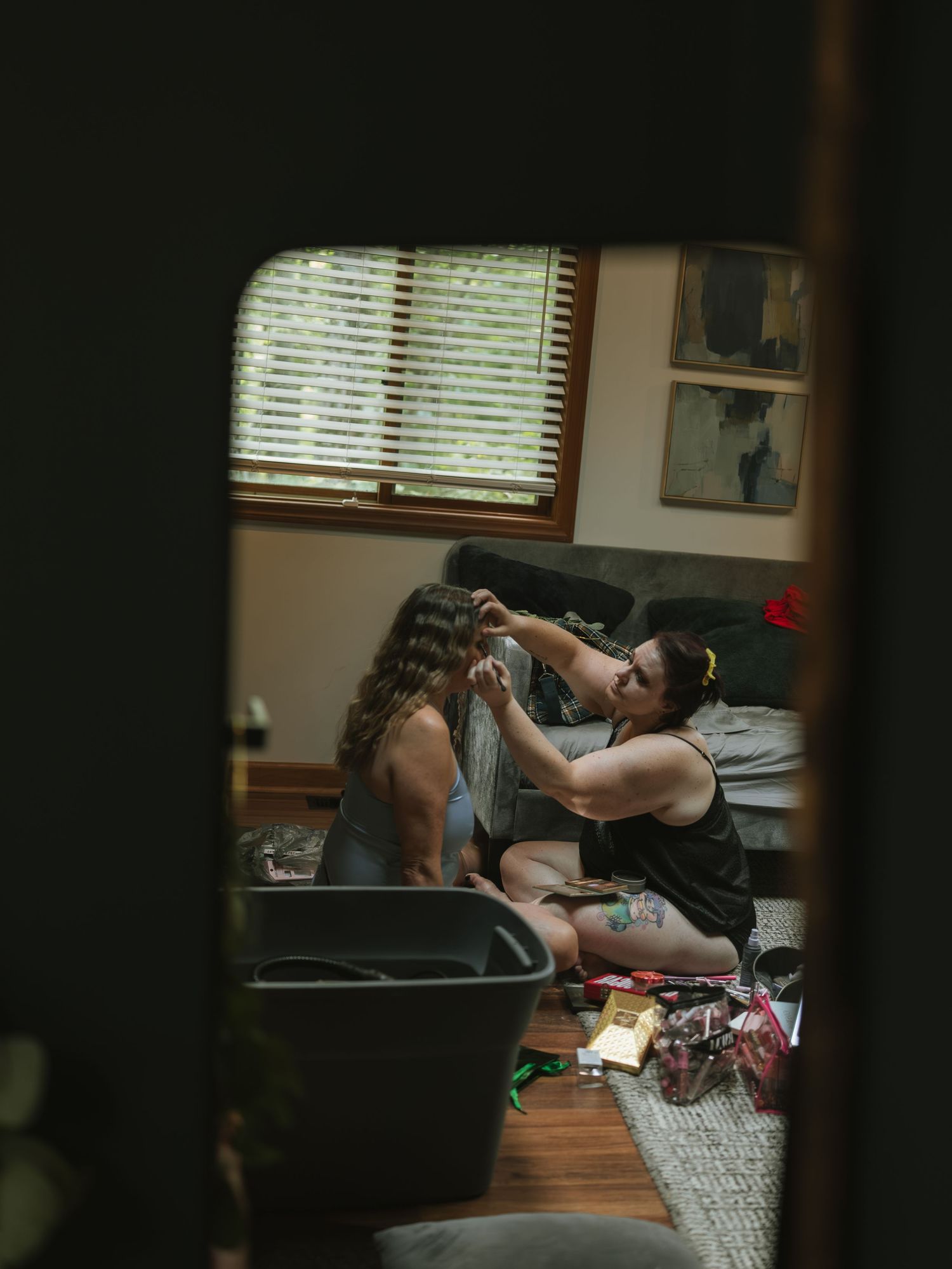 Couple sharing an intimate moment while resting on a couch in a dimly lit room.