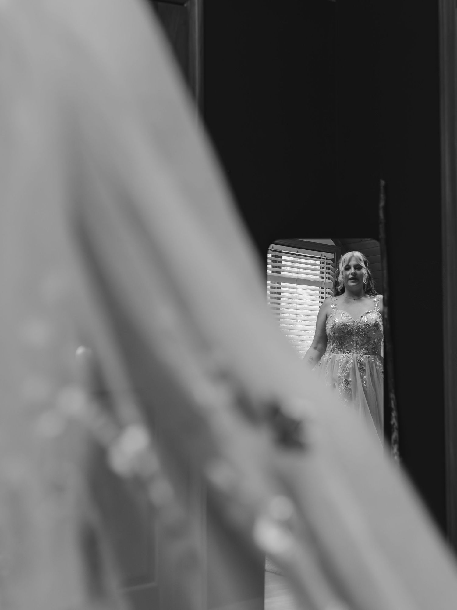 Black and white reflection of a wedding dress in a mirror.