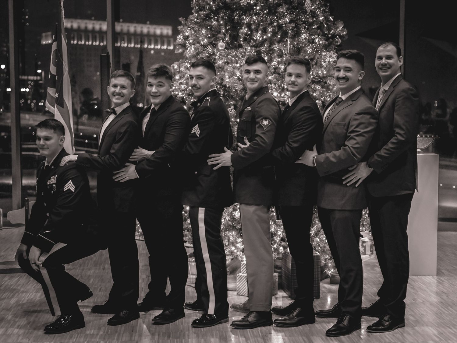 Group in formal attire posing together in a vintage black and white photograph.