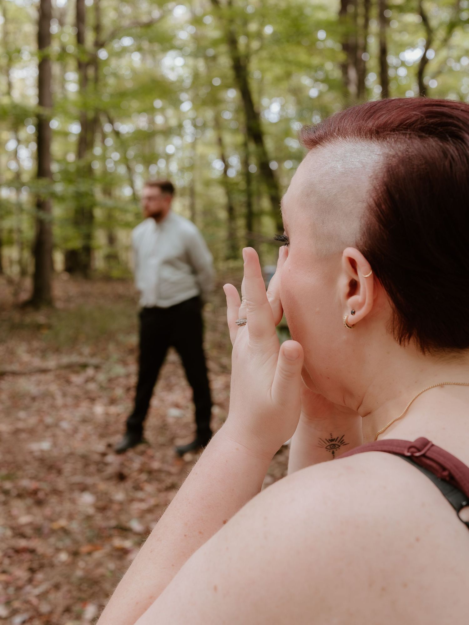 Wedding photographer capturing candid moments in a forest setting.